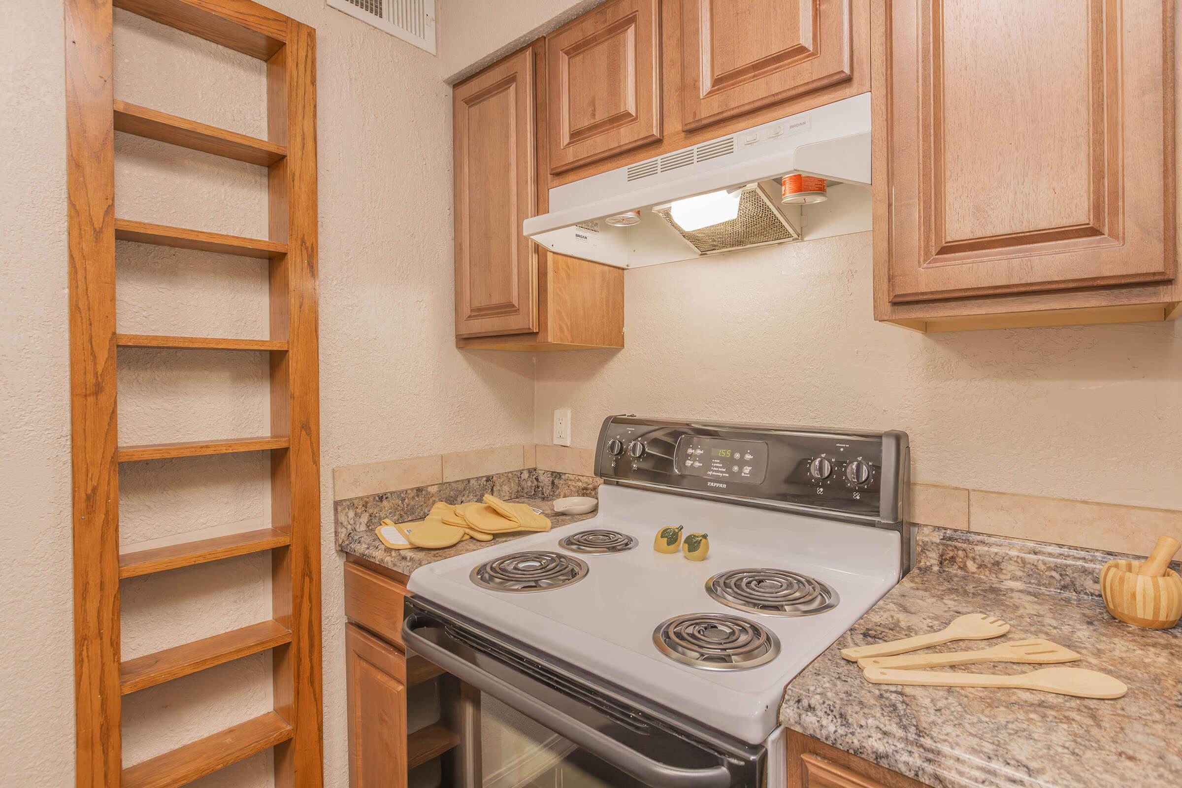 a stove top oven sitting inside of a kitchen