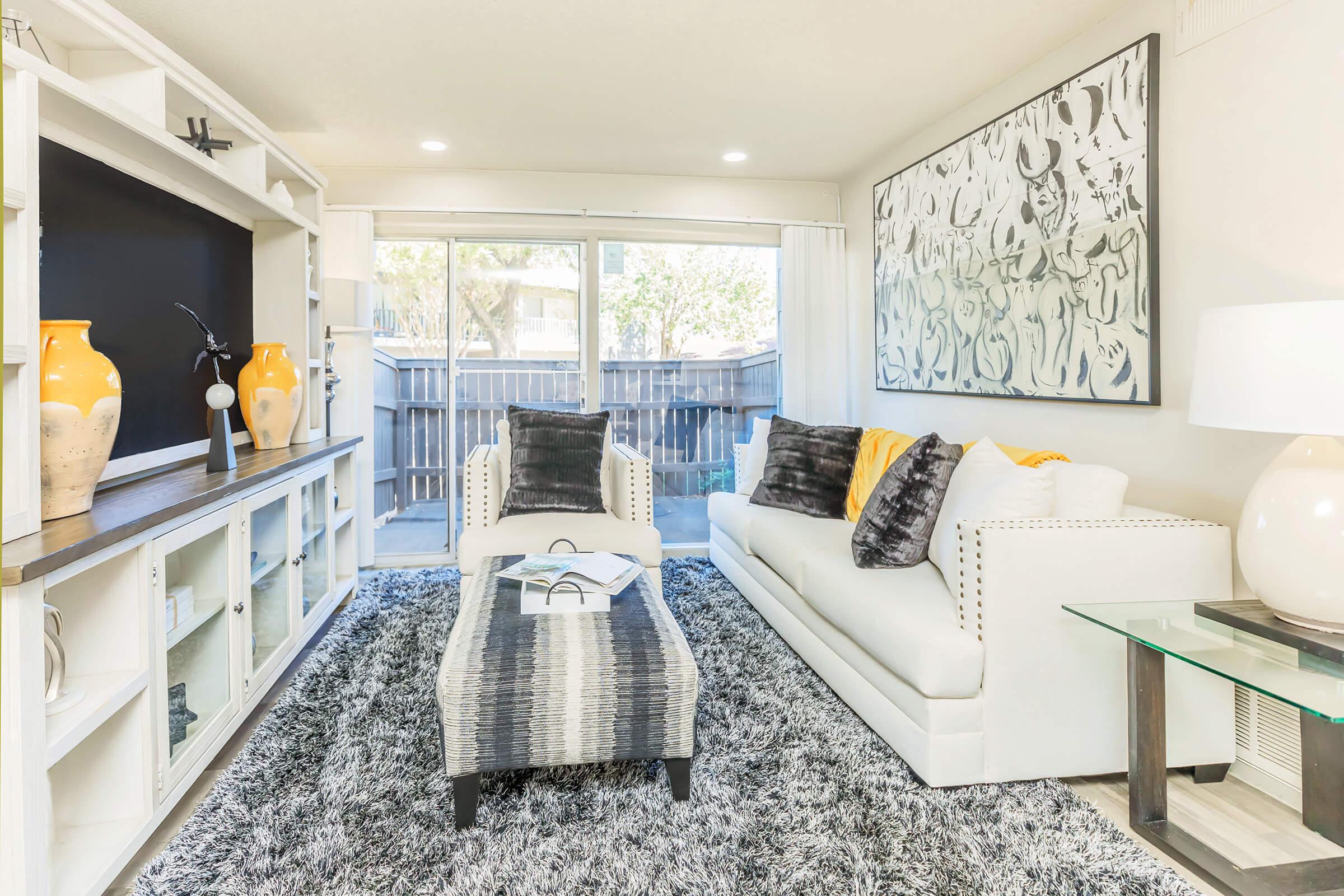 a living room filled with furniture and a large window