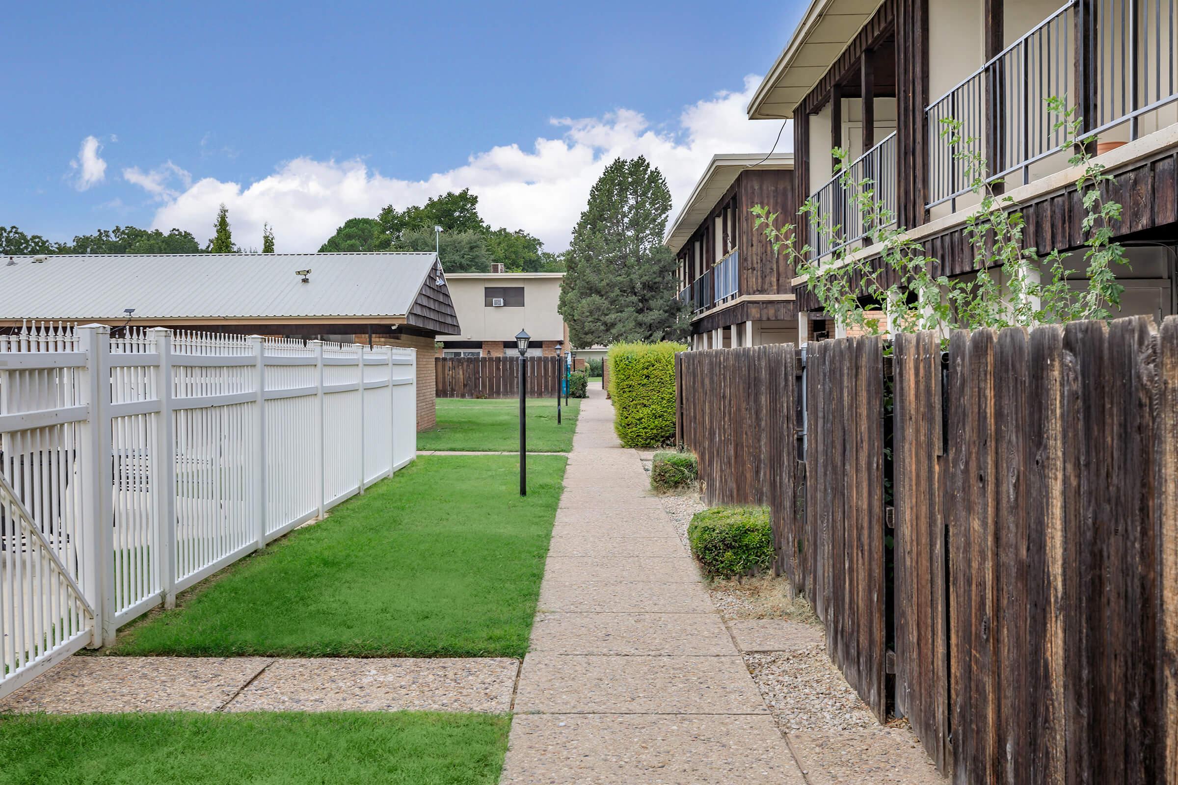 a house with a fence in front of a building