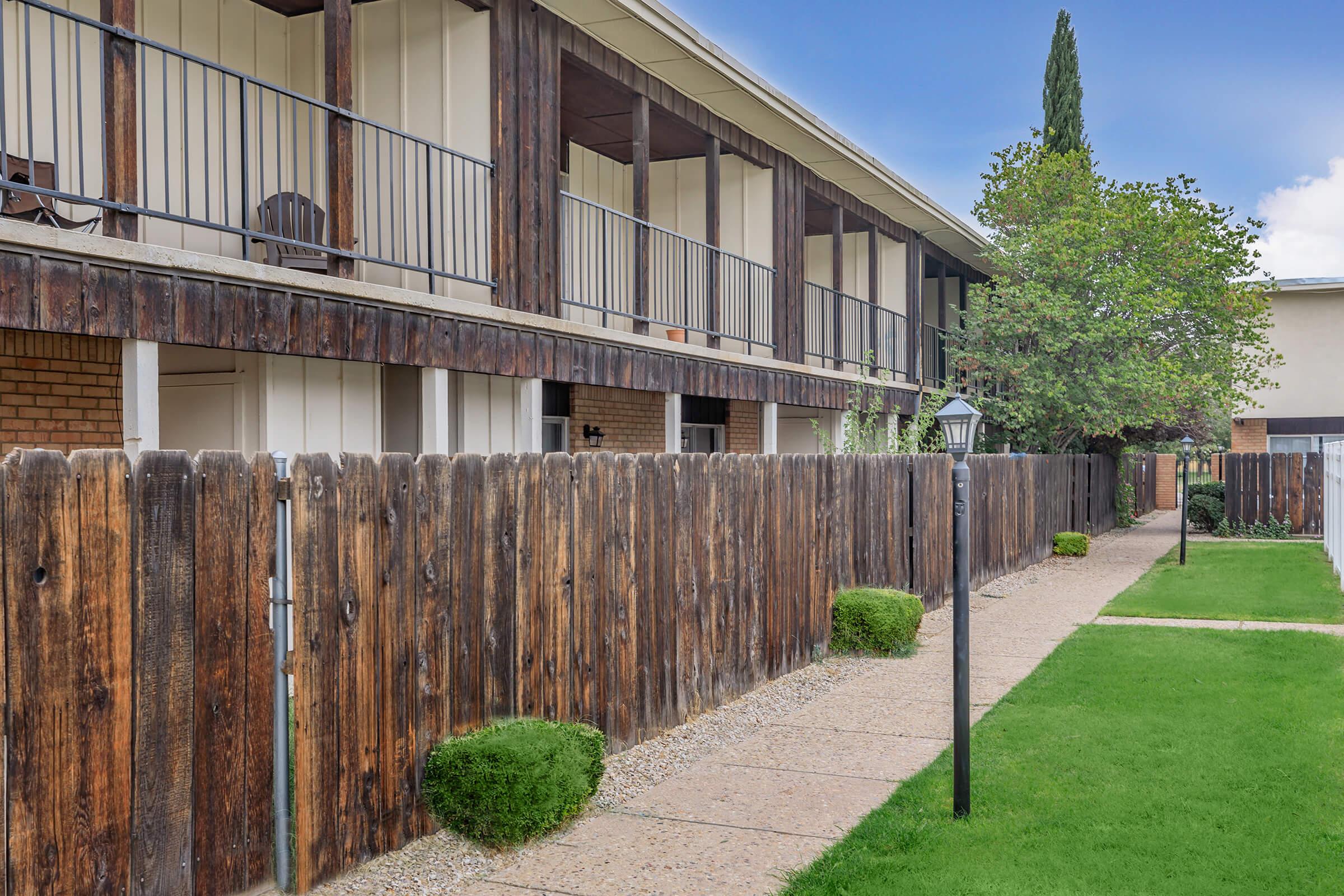 a house with a fence in front of a building