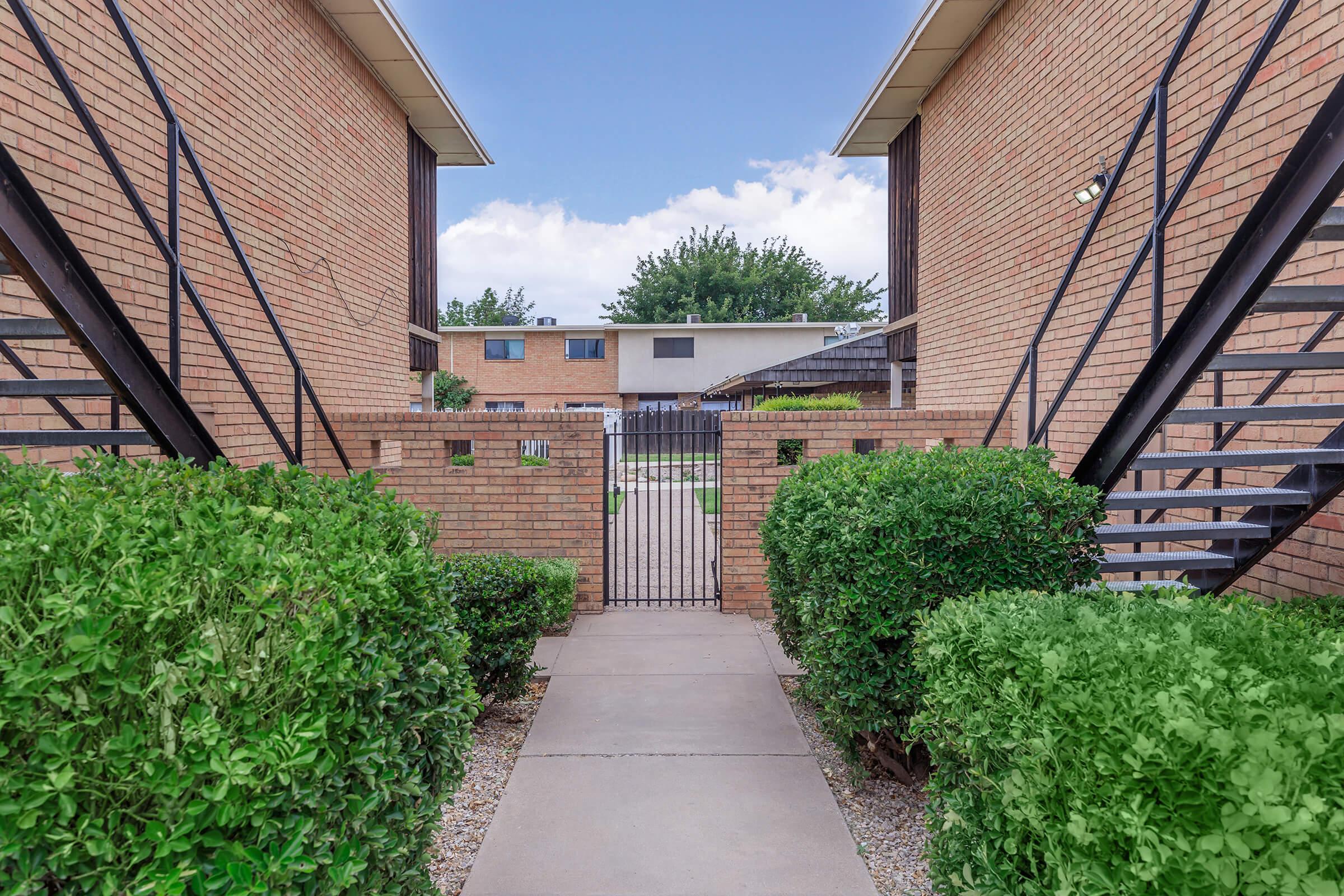 a house with bushes in front of a brick building