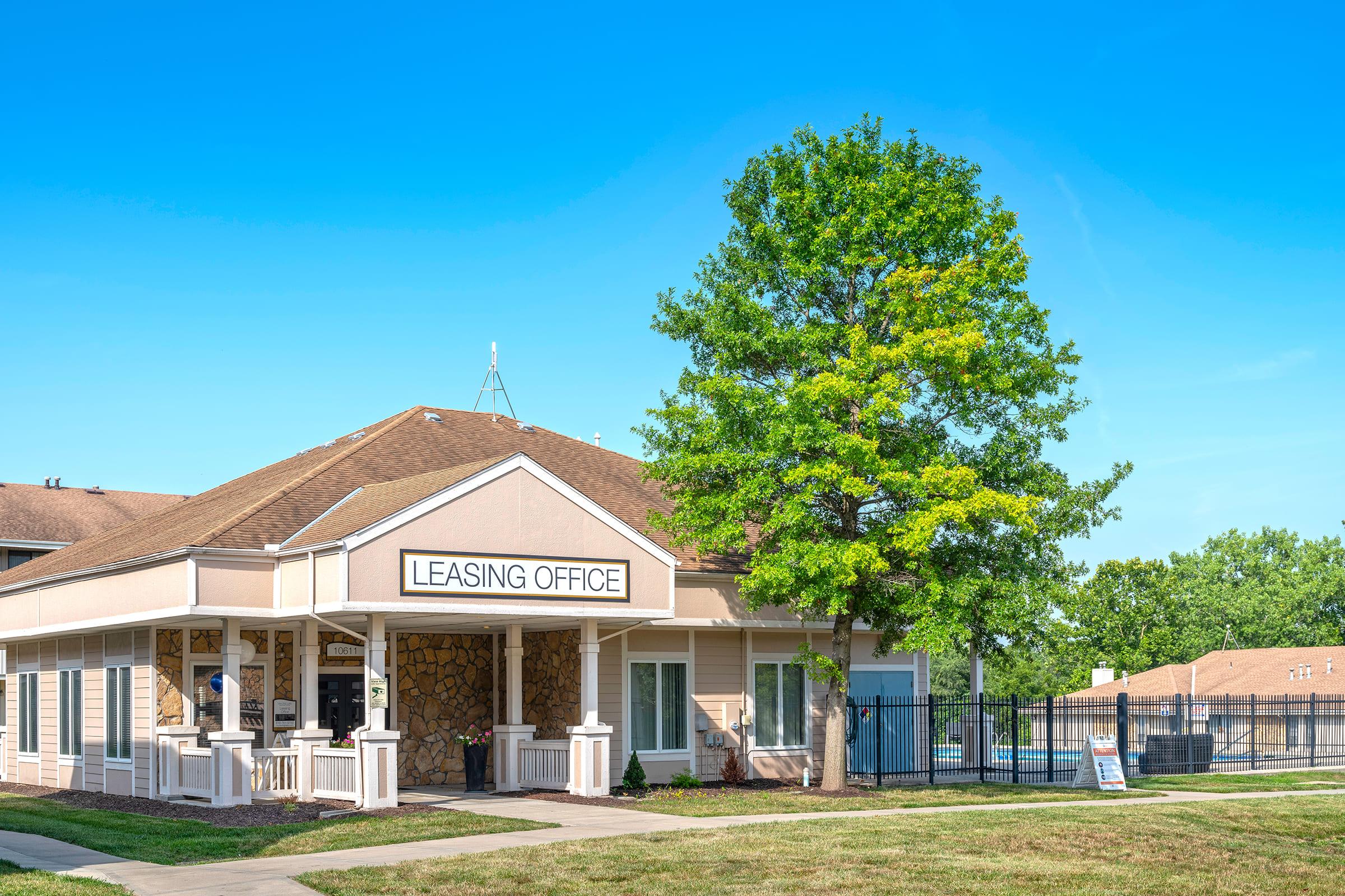 a large brick building with grass in front of a house