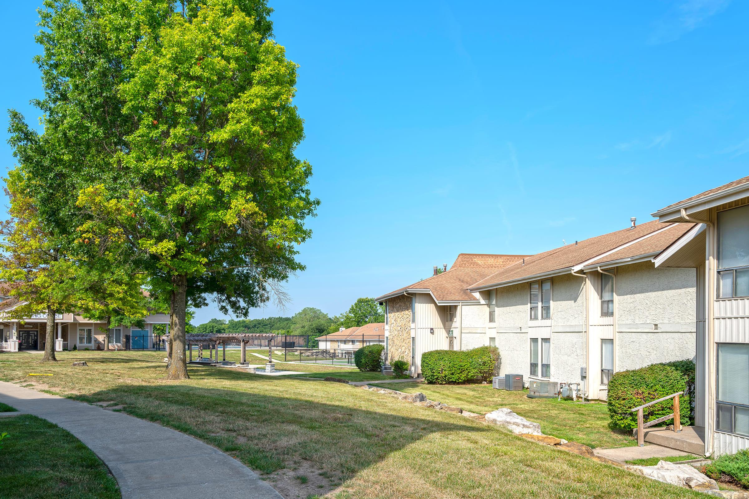 a large brick building with grass in front of a house