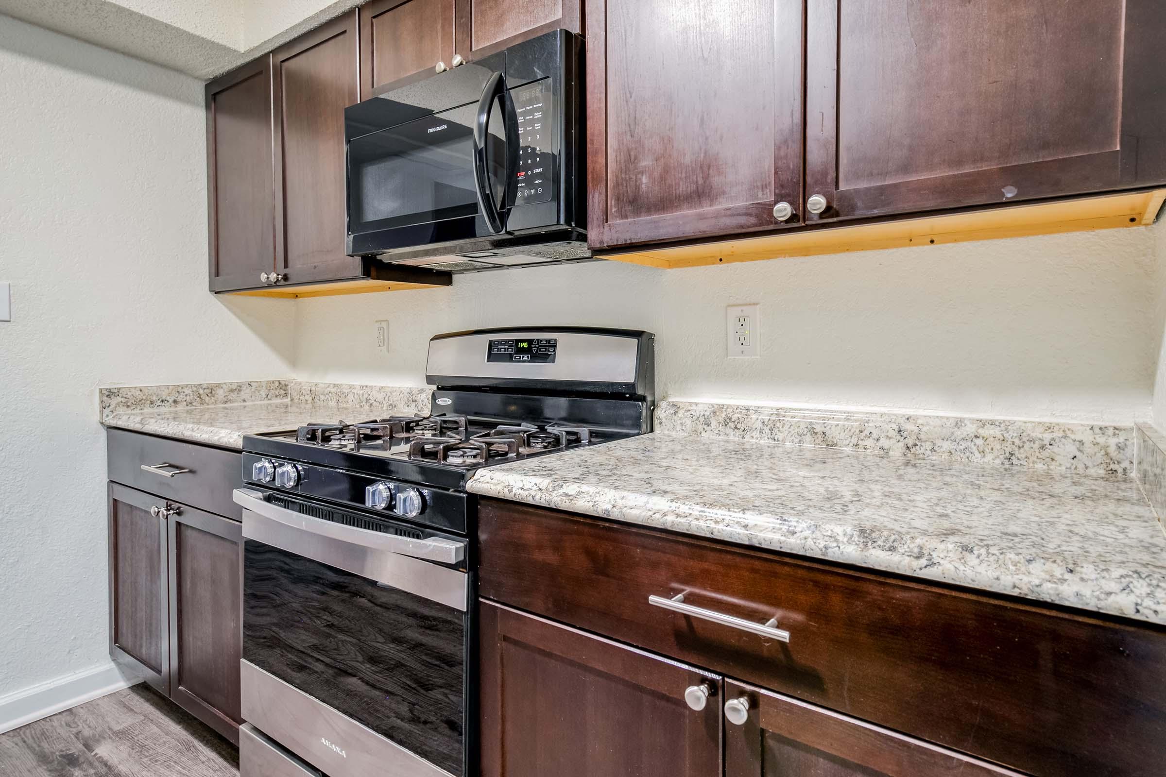 a kitchen with a stove a sink and a microwave