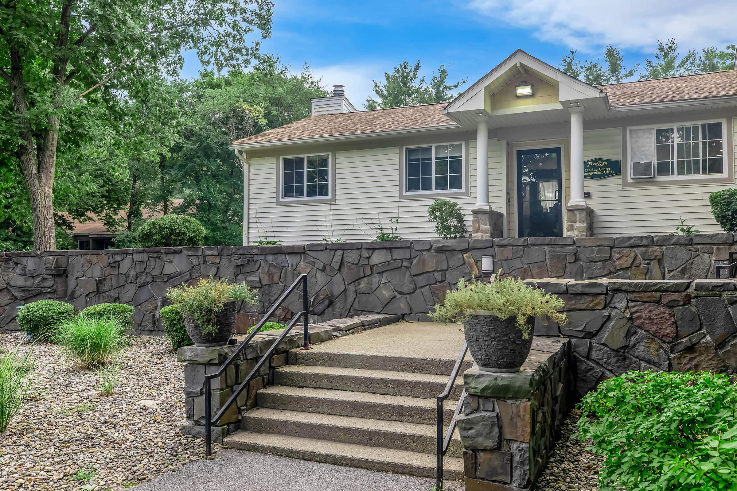 a house with bushes in front of a brick building