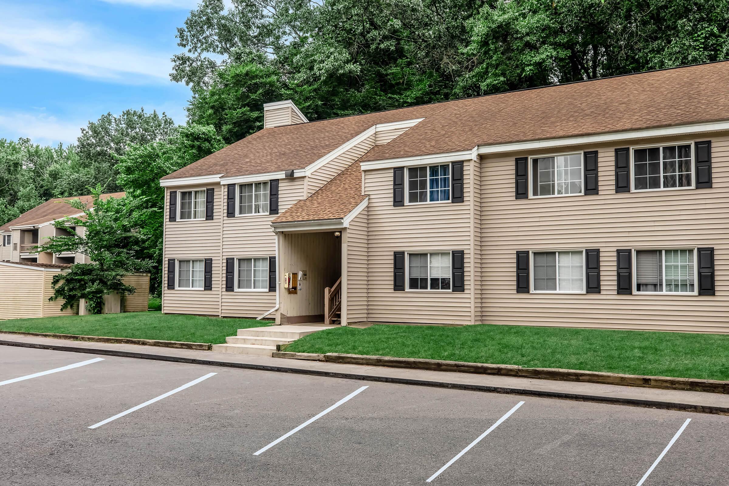 a large brick building with grass in front of a house