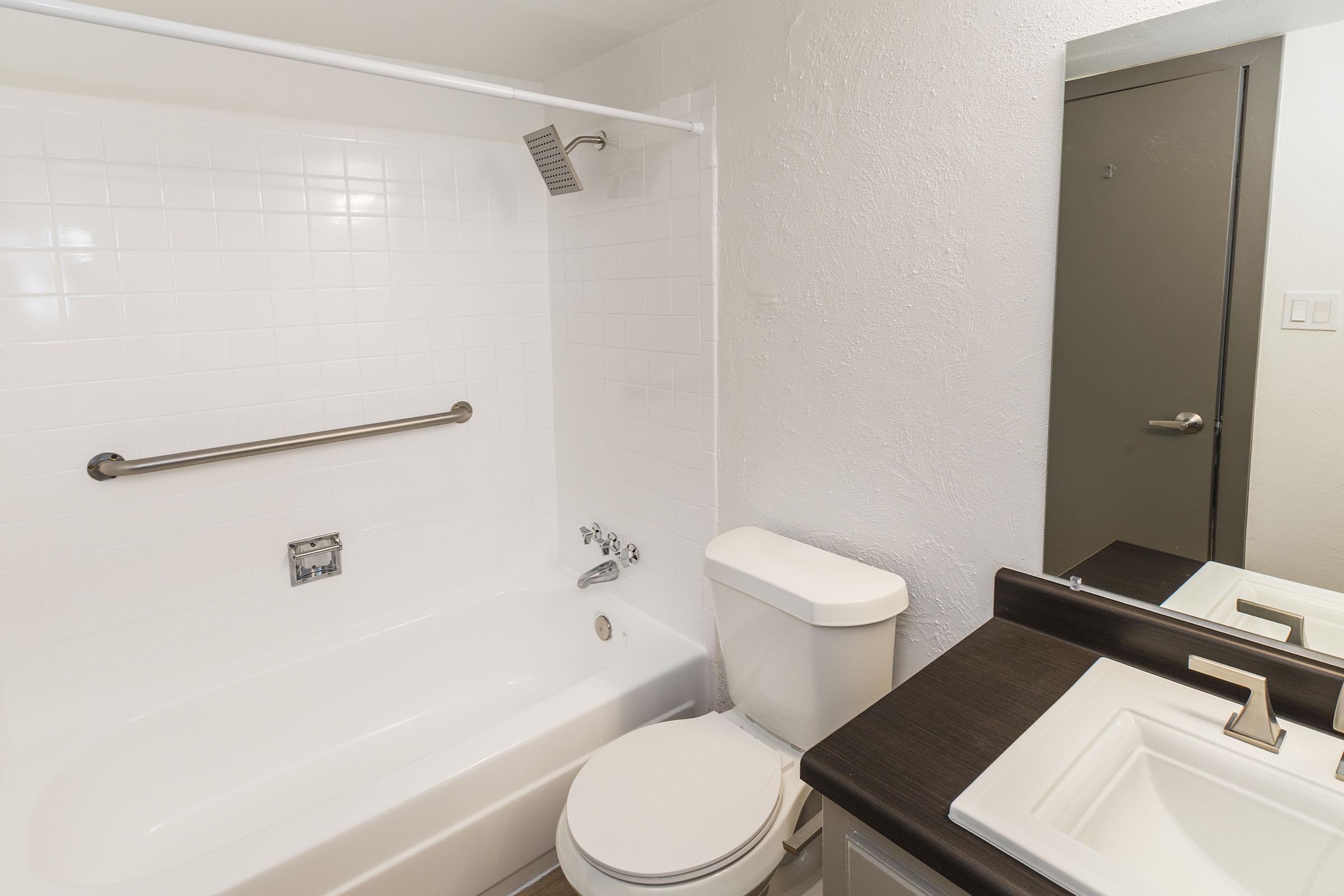 a white sink sitting under a mirror