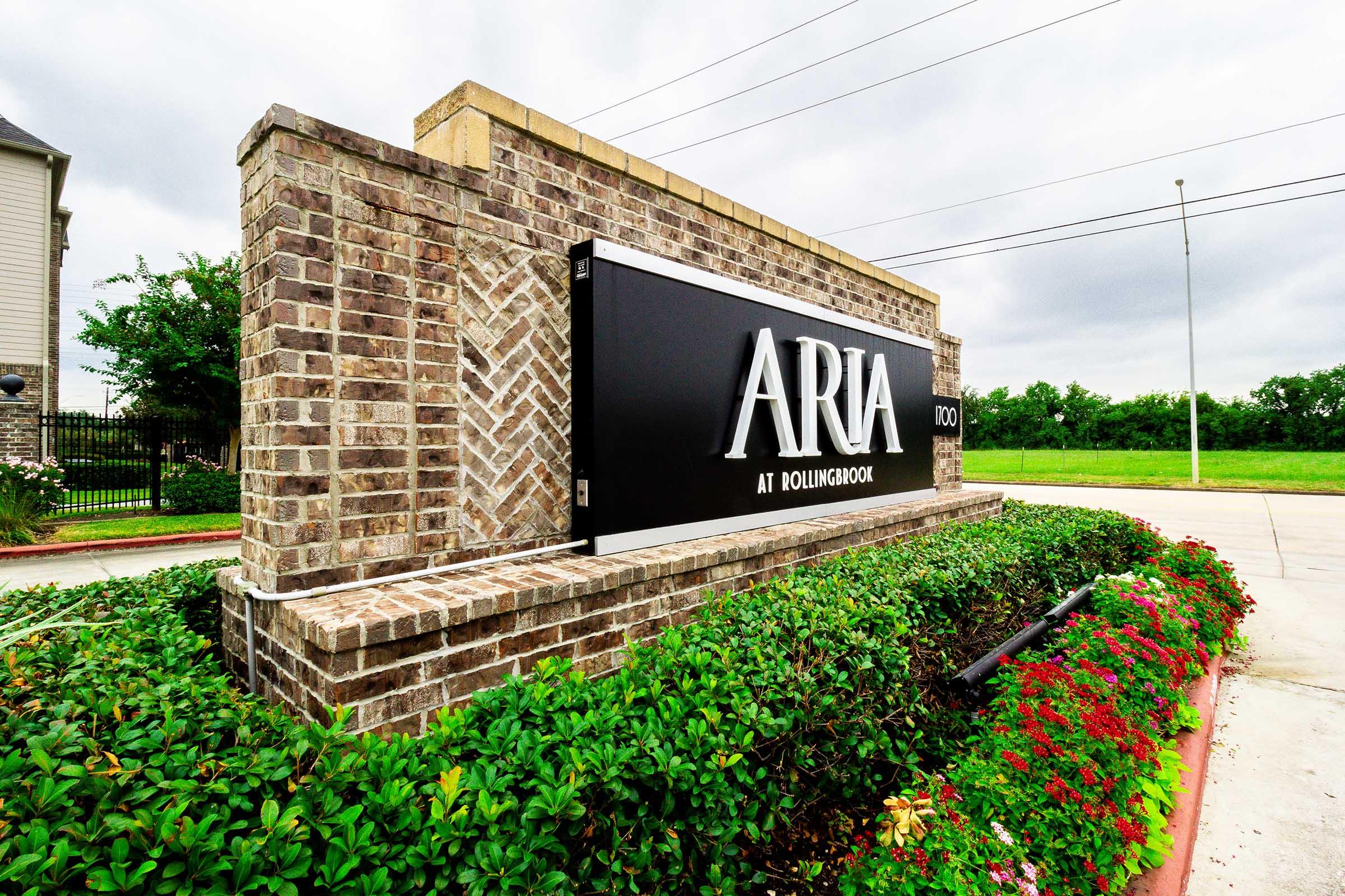 a large brick building with green grass