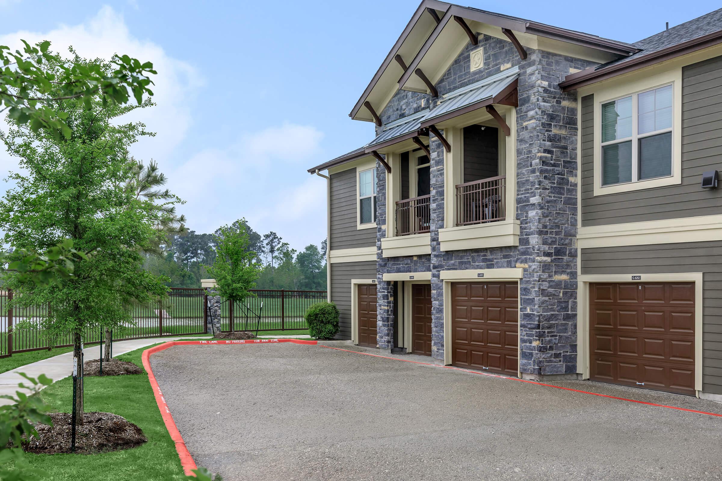 Attached garages at Park at Tour 18 apartments and paved walking trail through the landscaping.