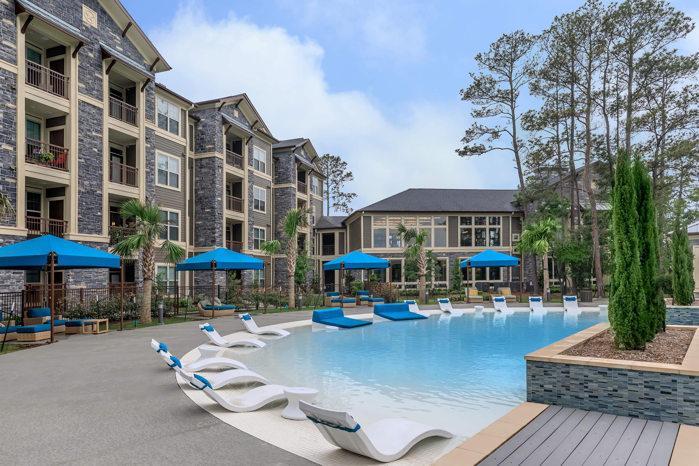 Beach entry pool with sunning area. Cabanas and Lounge chairs surrounding the pool.