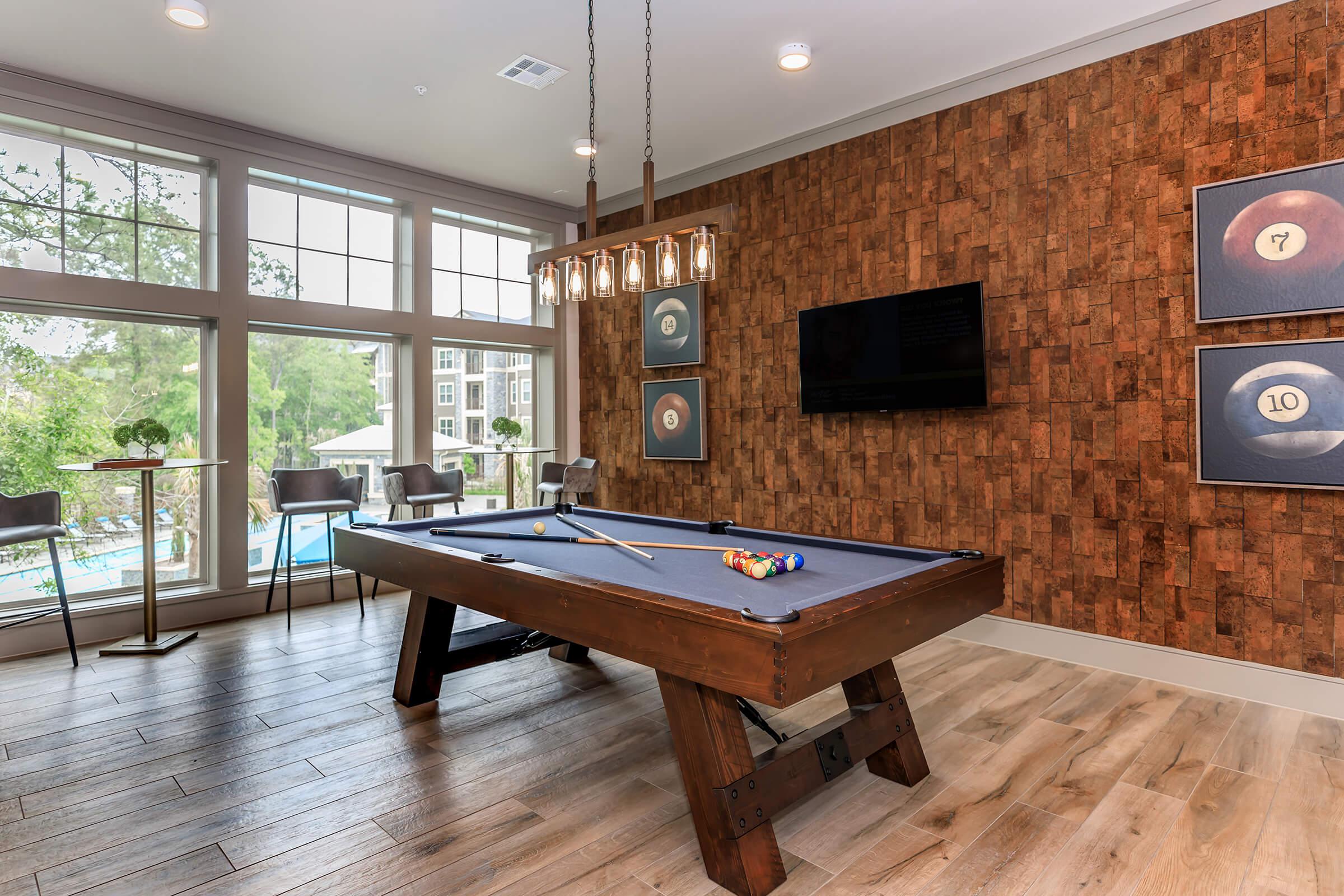 Billiards area of our upscale clubhouse with large windows and seating.