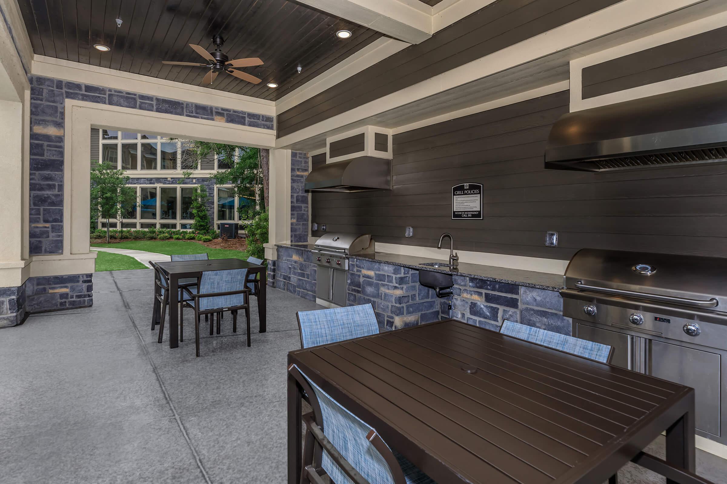 Indroo grill house at Park at Tour 18 with seating, grills with vent hoods, and sink.