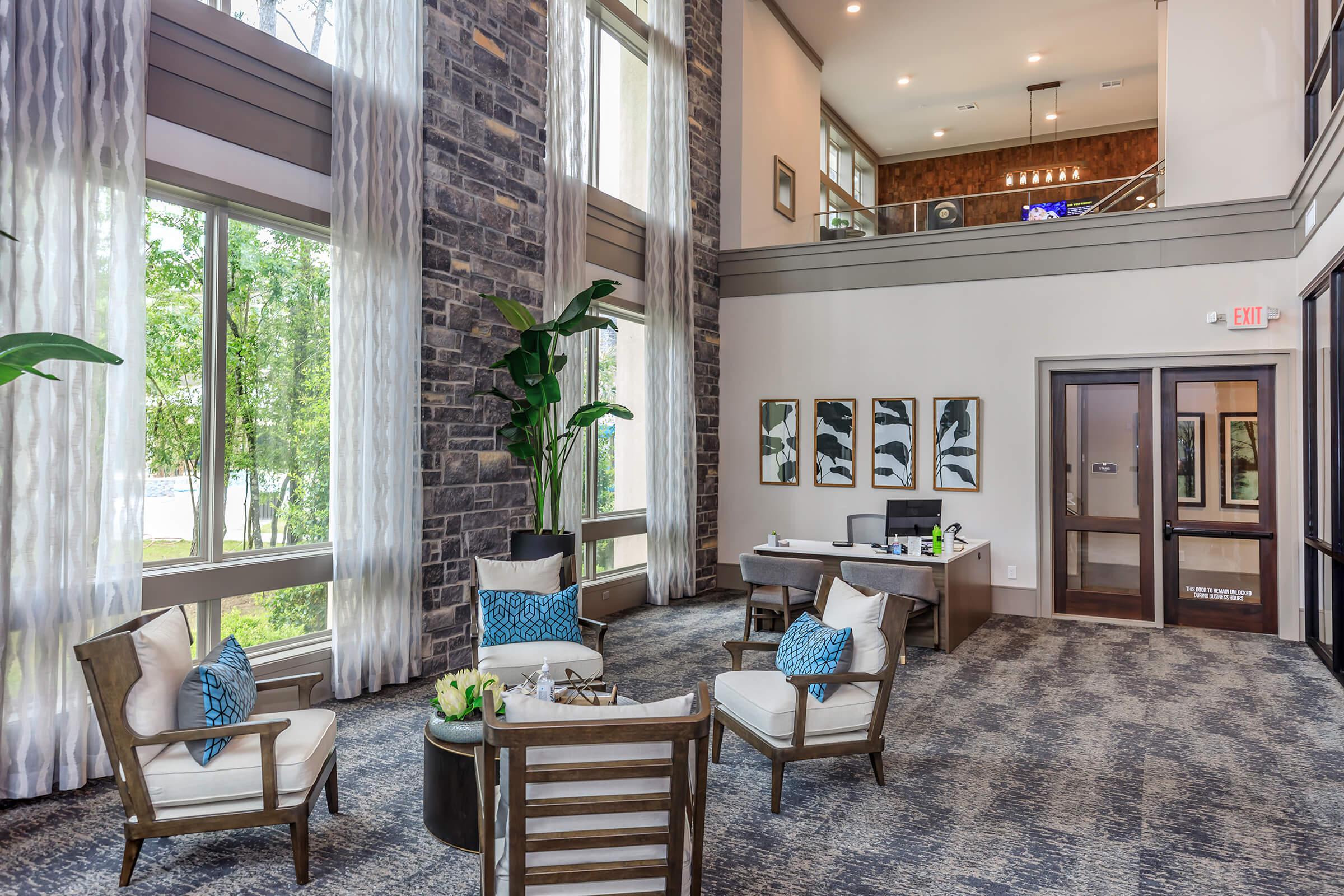 Upscale leasing office and clubhouse interior full of natural light from large windows.