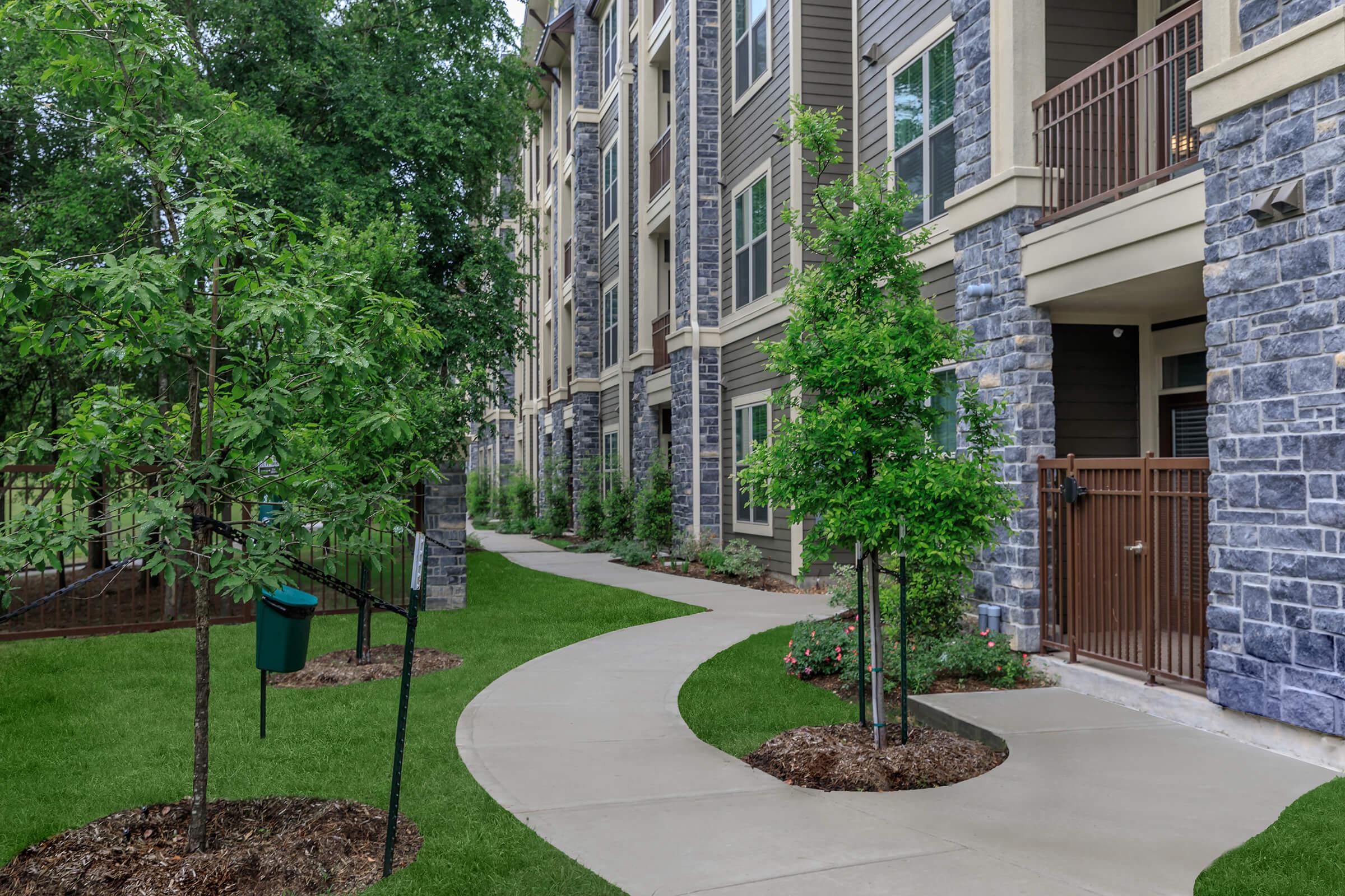Walking paths through lush landscaping with pet waste stations.