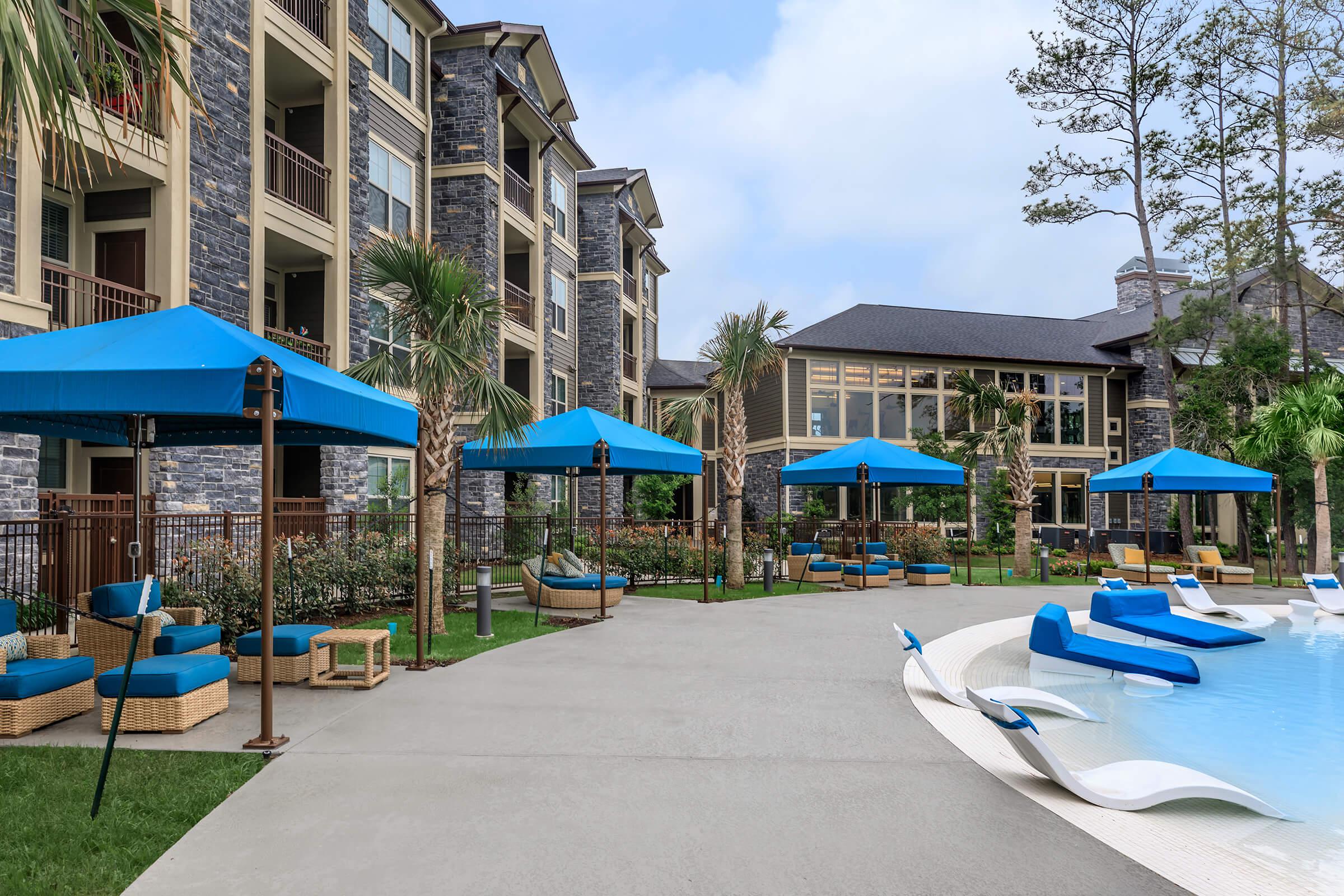 Cabanas in blue surrounding the beach entry area of our resort-style pool.