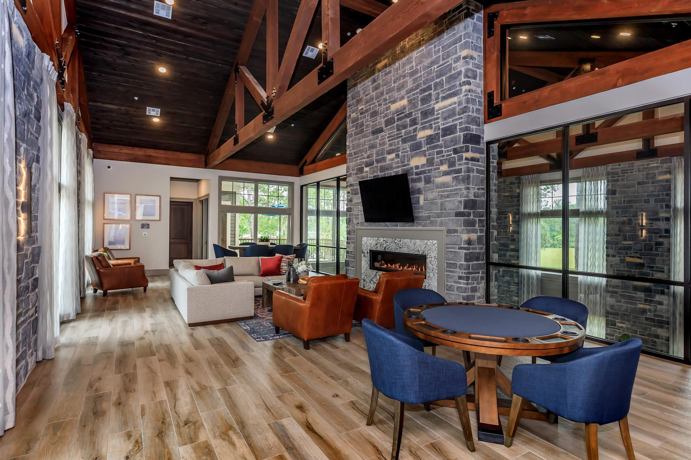 Upscale resident lounge showing multiple seating areas, TX, fireplace, and wood floors.
