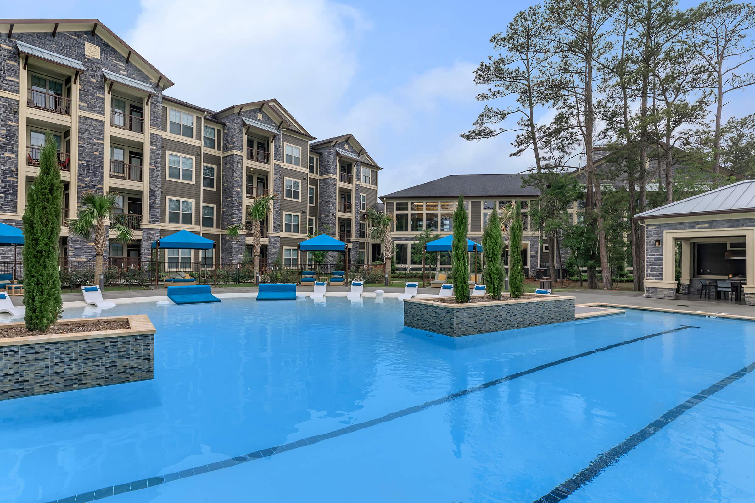 Gorgeous pool with beach entry area. Apartment building in the background