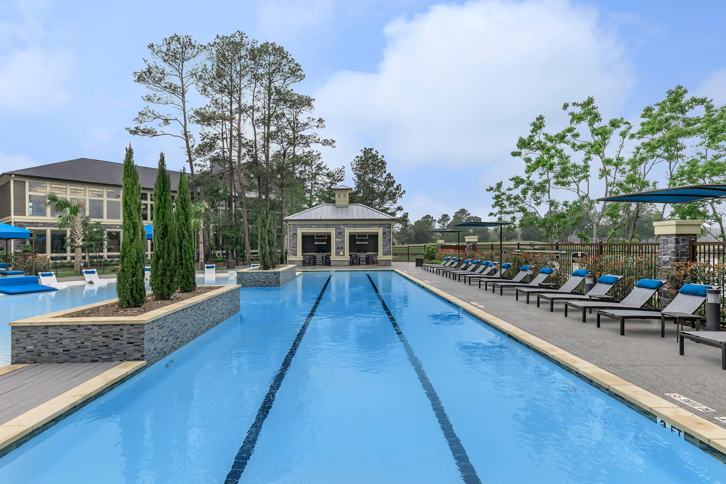 Large resort-style pool with lounge chairs to the right and connected beach entry area on the left.