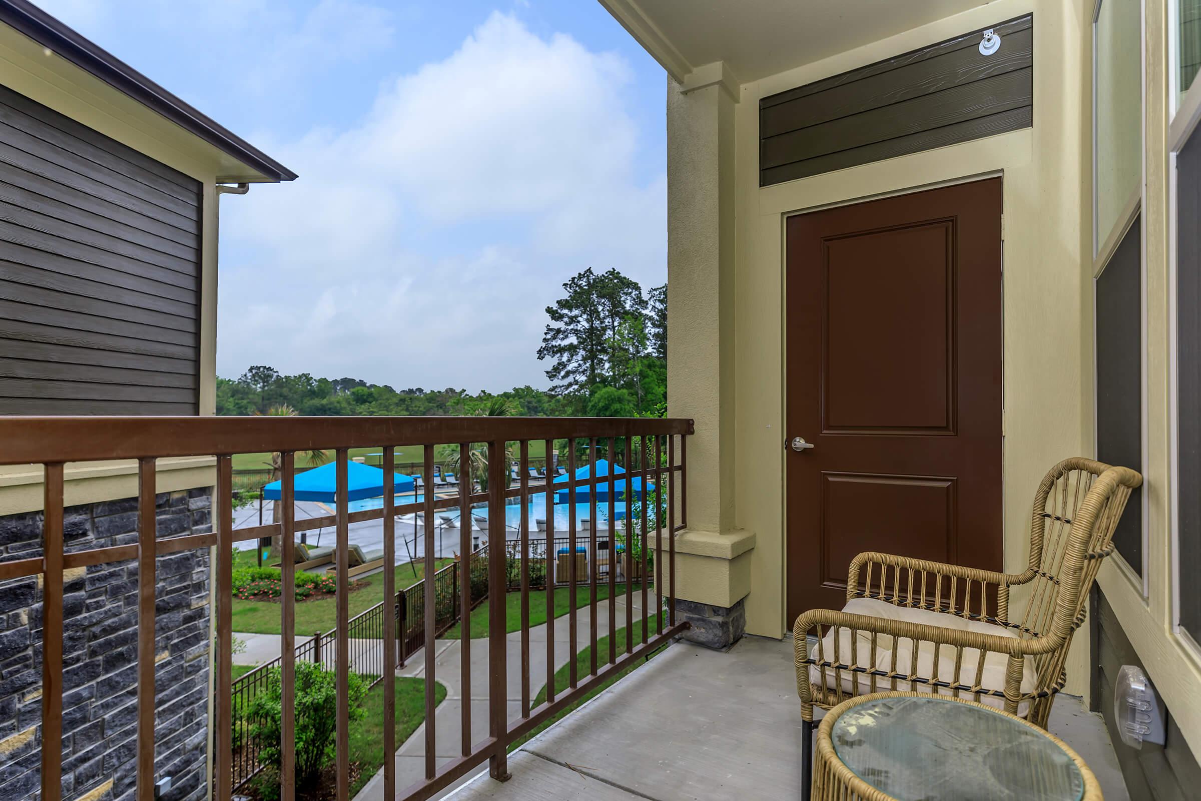 Beautiful views from an apartment balcony. Open green scape of the golf couse behind pool cabanas.
