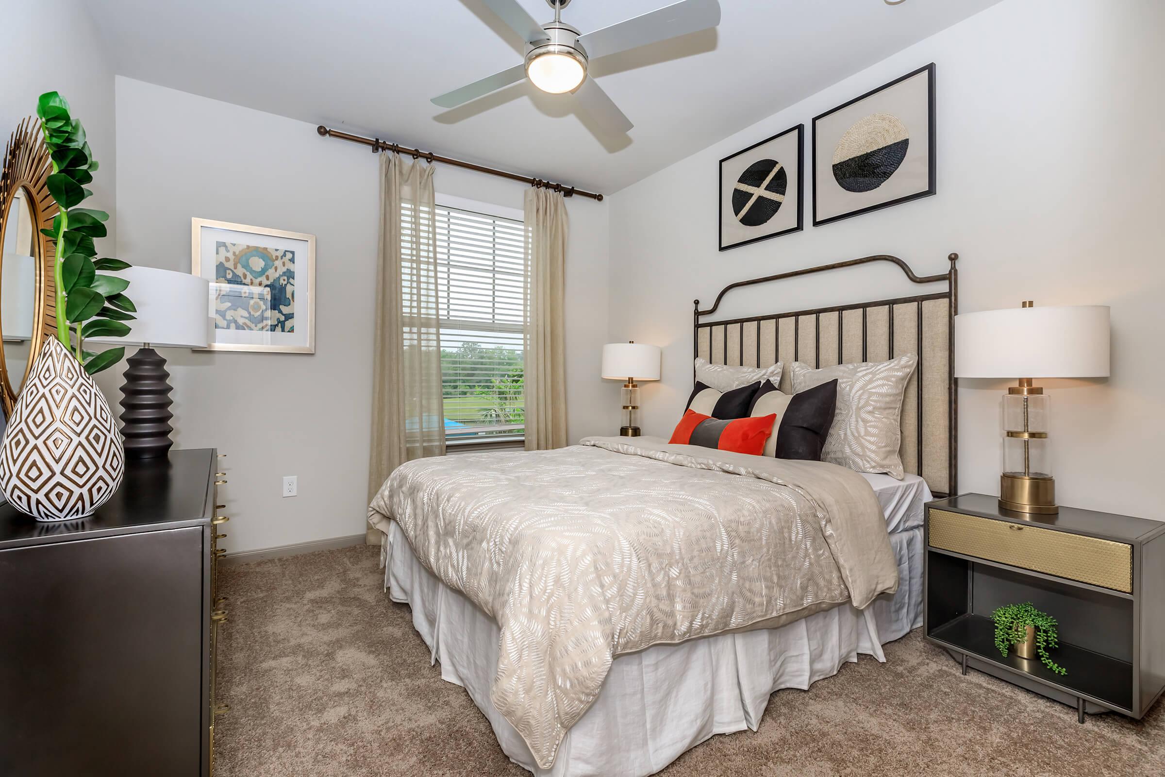 Serene bedroom staged with furniture and open window view of golf course.