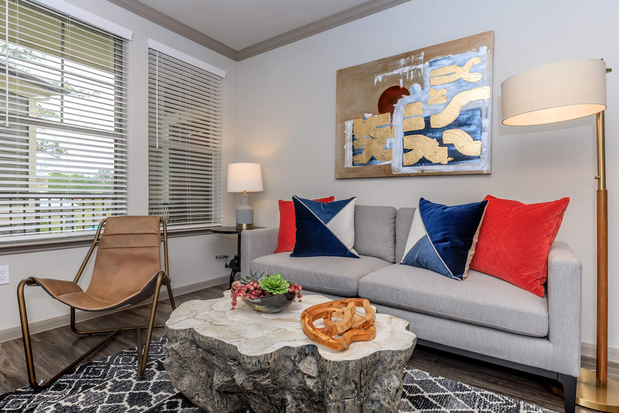 Furnished living room with couch, chair, unique wood stump table, and area rug.