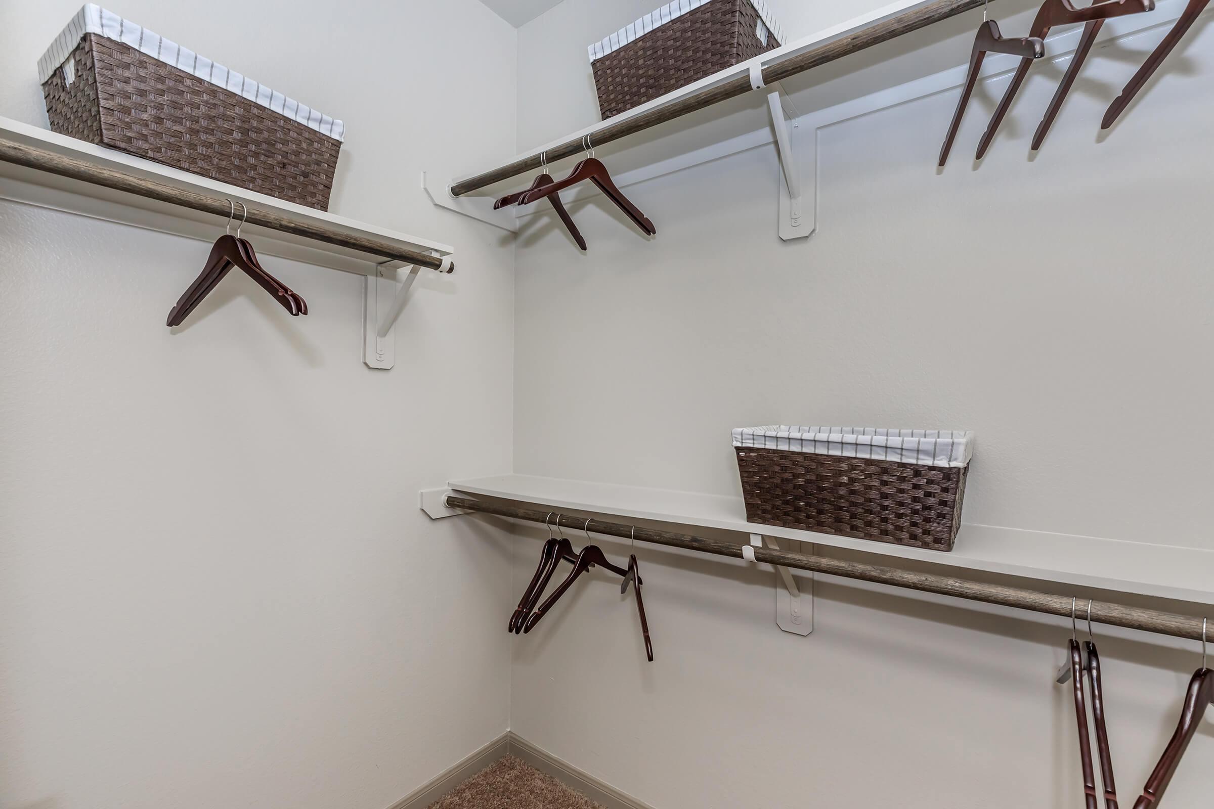 Walk-in closet. 3 shelving heights and handing areas in view.