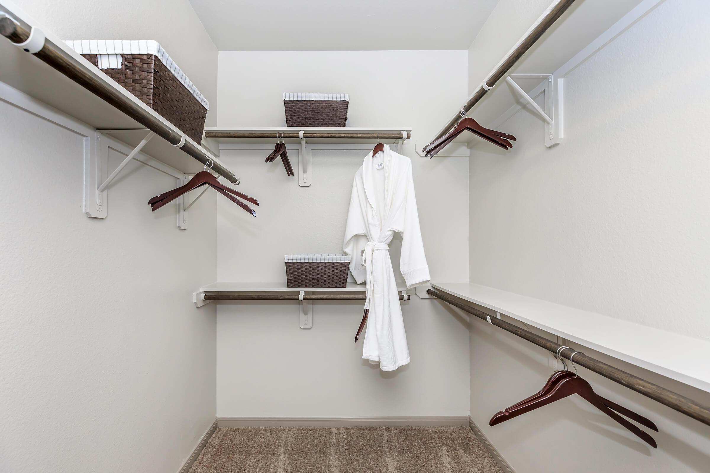 Spacious walk-in closet with multiple shelves and handing areas.