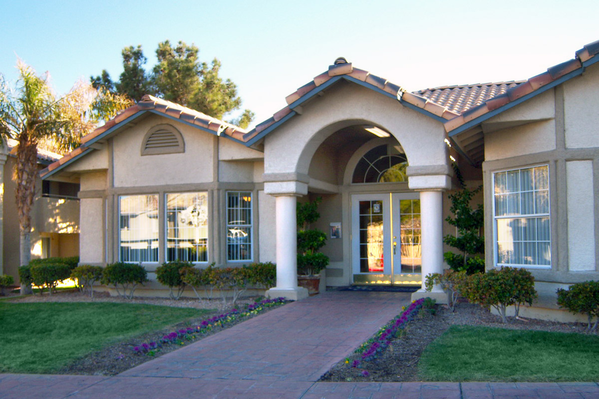 a large brick building with grass in front of a house