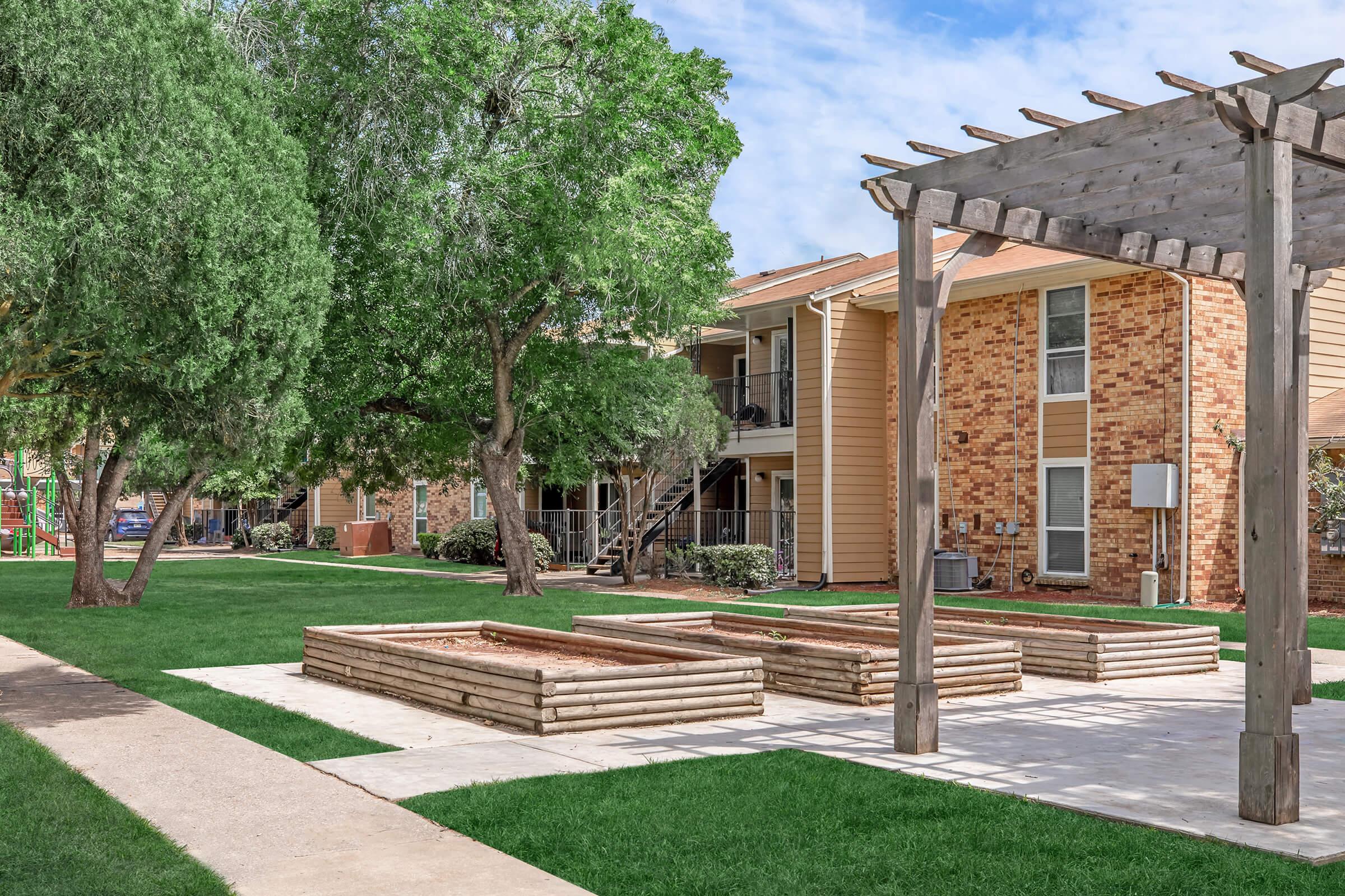 a large brick building with grass and trees