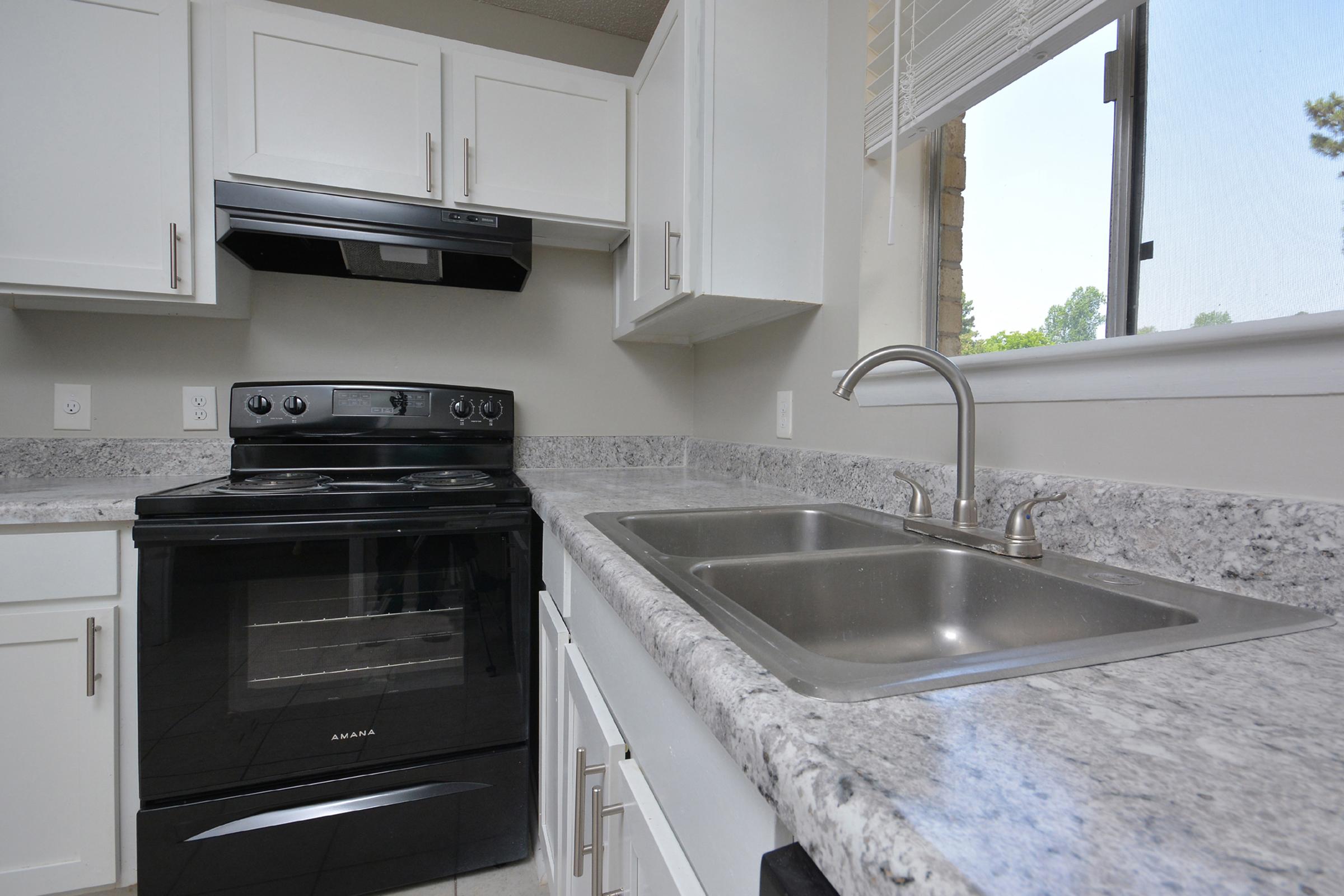 a stove top oven sitting inside of a kitchen