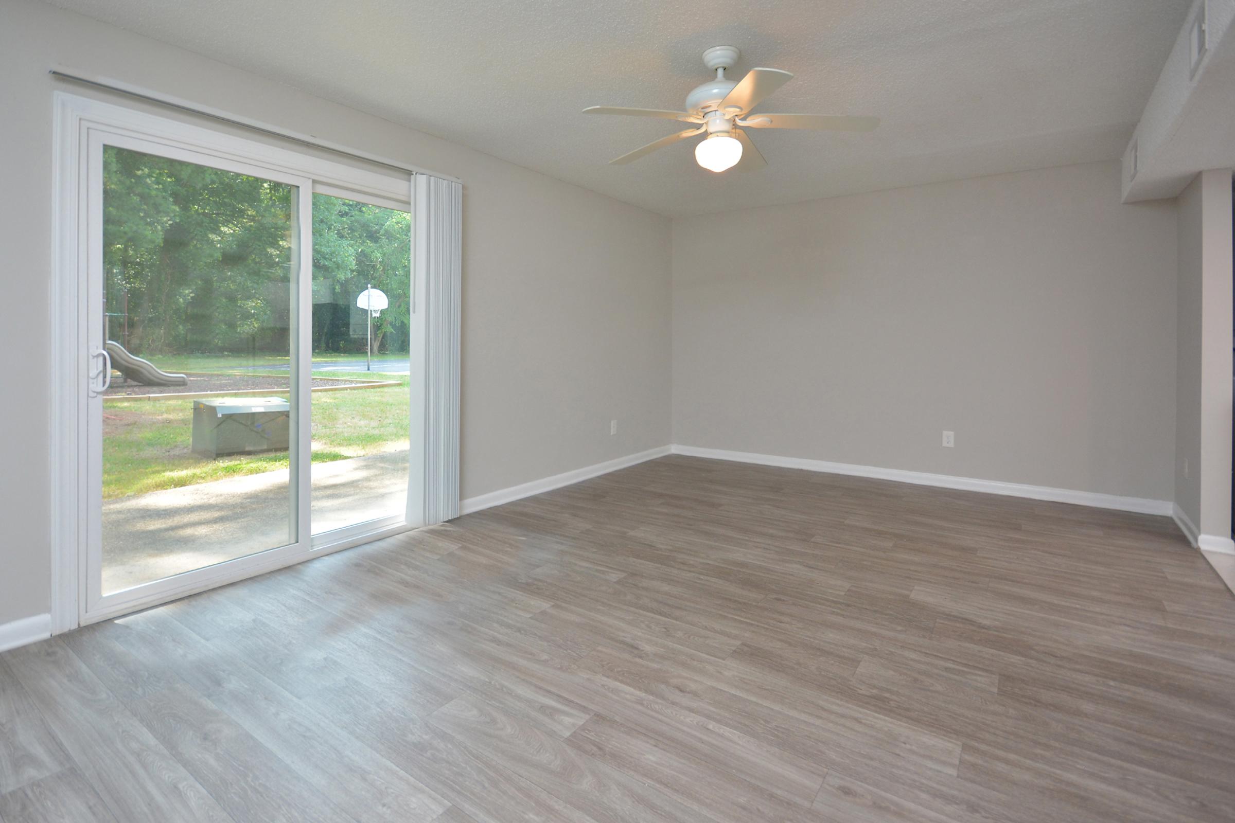 a room with wooden floors and a large window