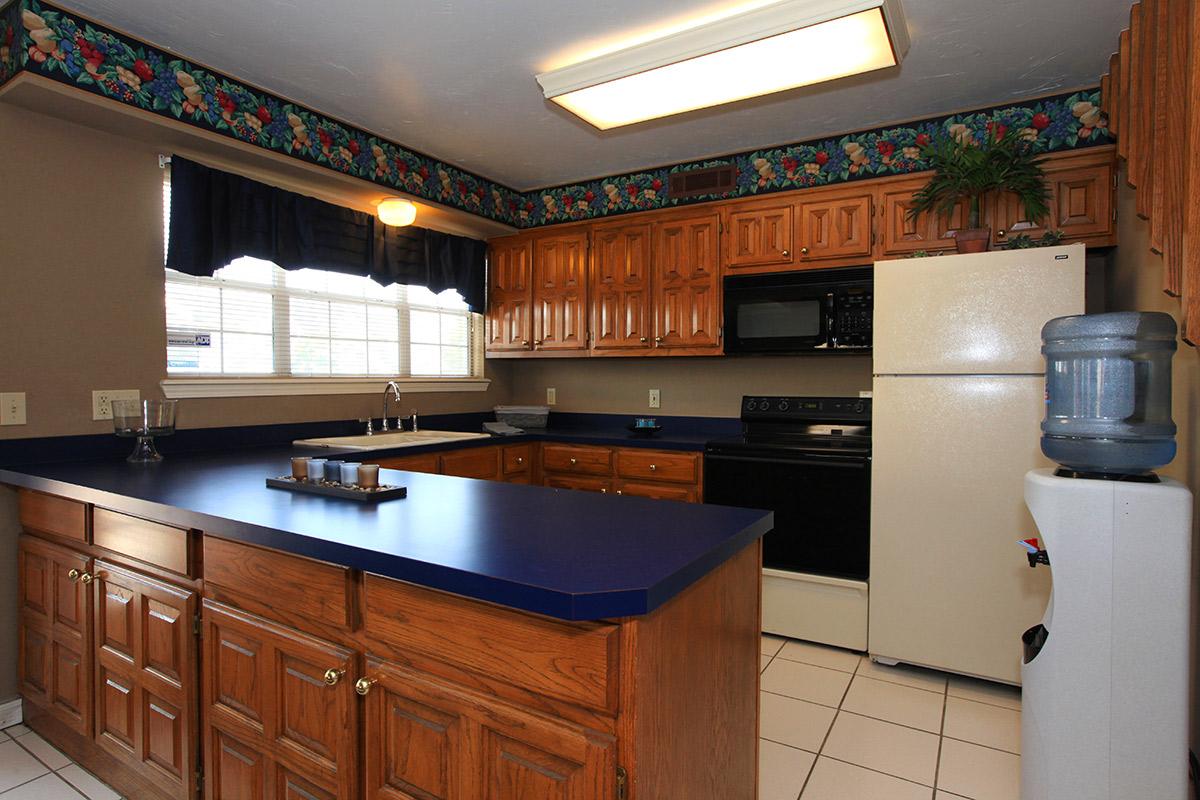 a large kitchen with stainless steel appliances and wooden cabinets