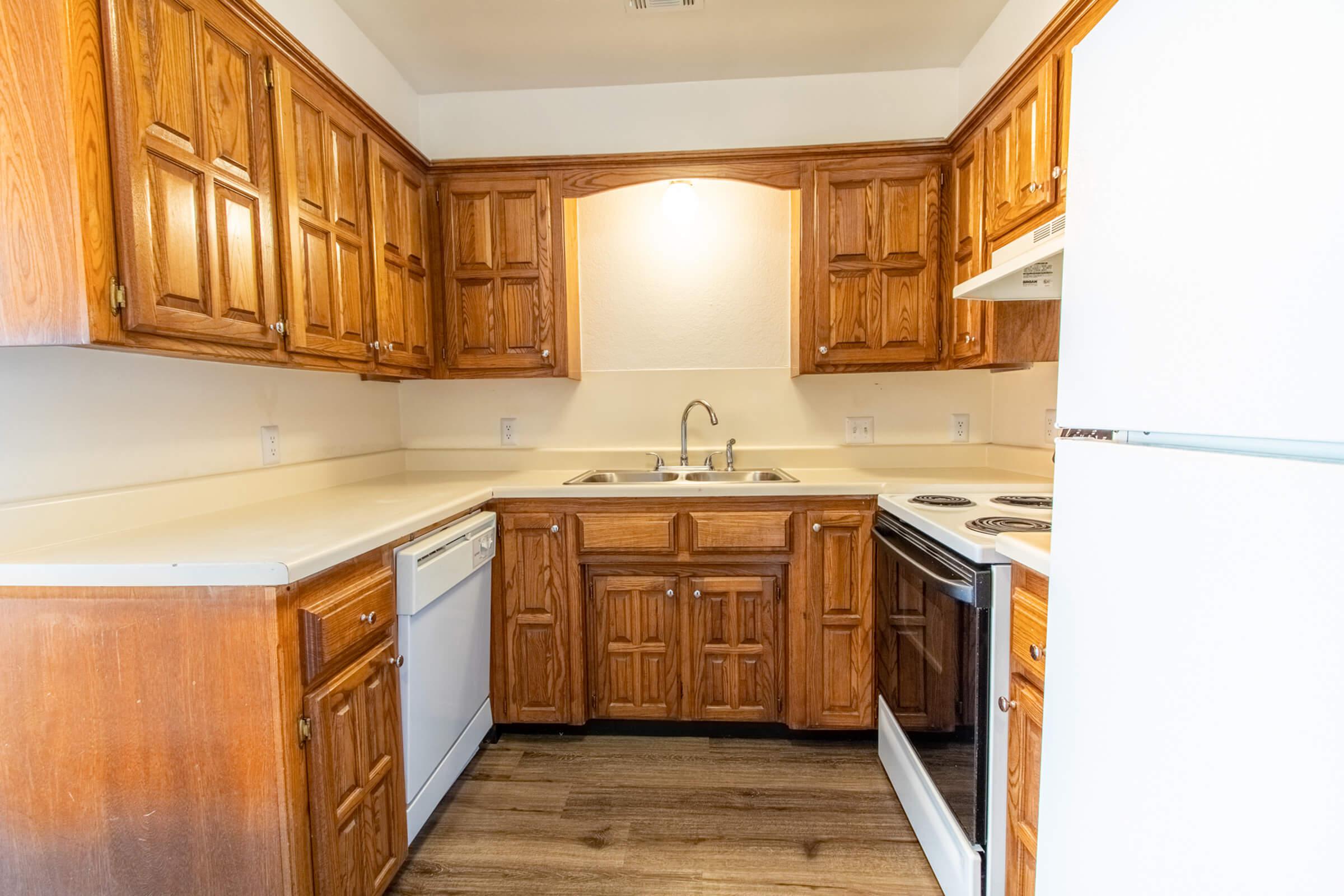 a kitchen with a stove refrigerator and wooden cabinets