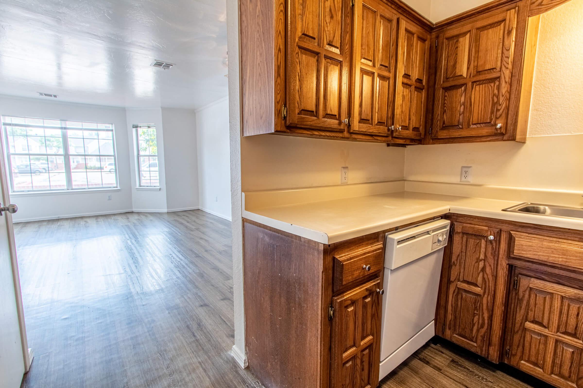 a kitchen with wooden cabinets and a wood floor