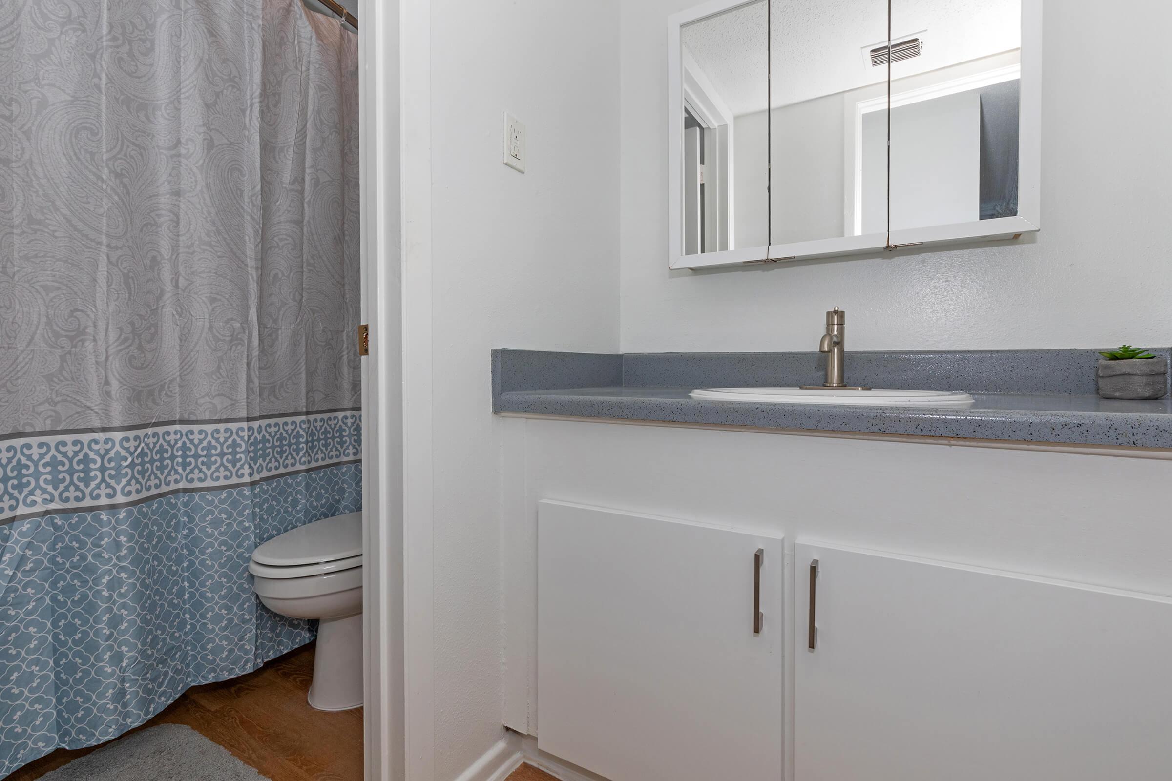 a white sink sitting next to a shower