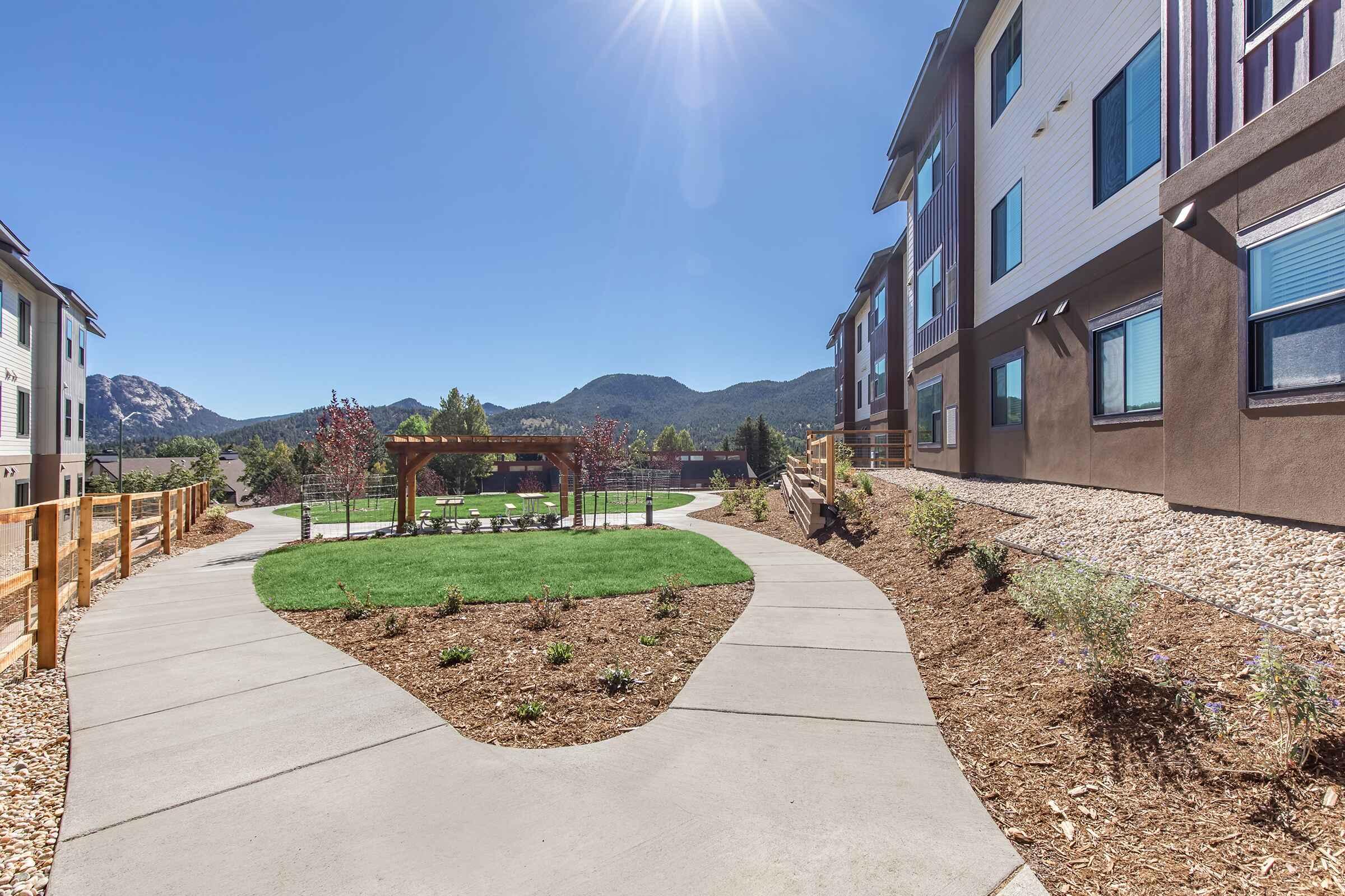 a path with trees on the side of a building