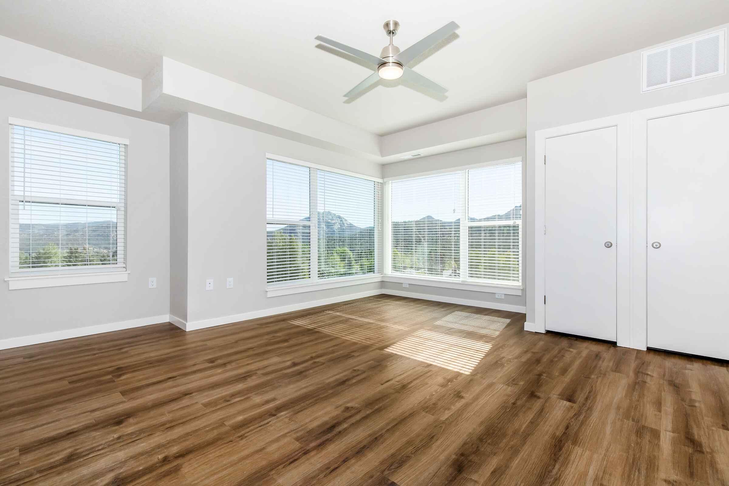 a room with wooden floors and a large window