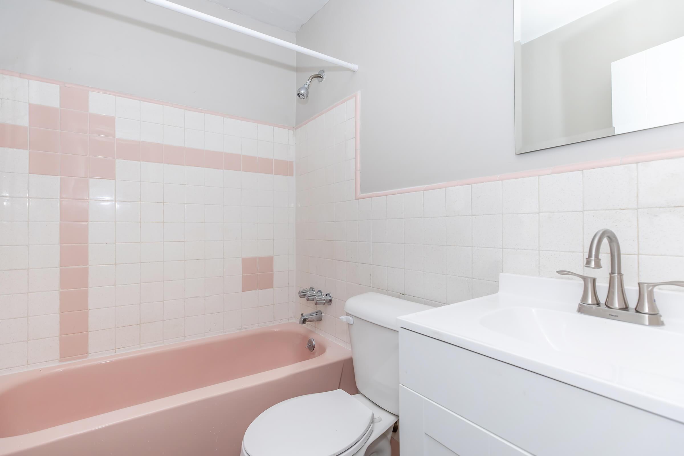 a close up of pink tub and sink