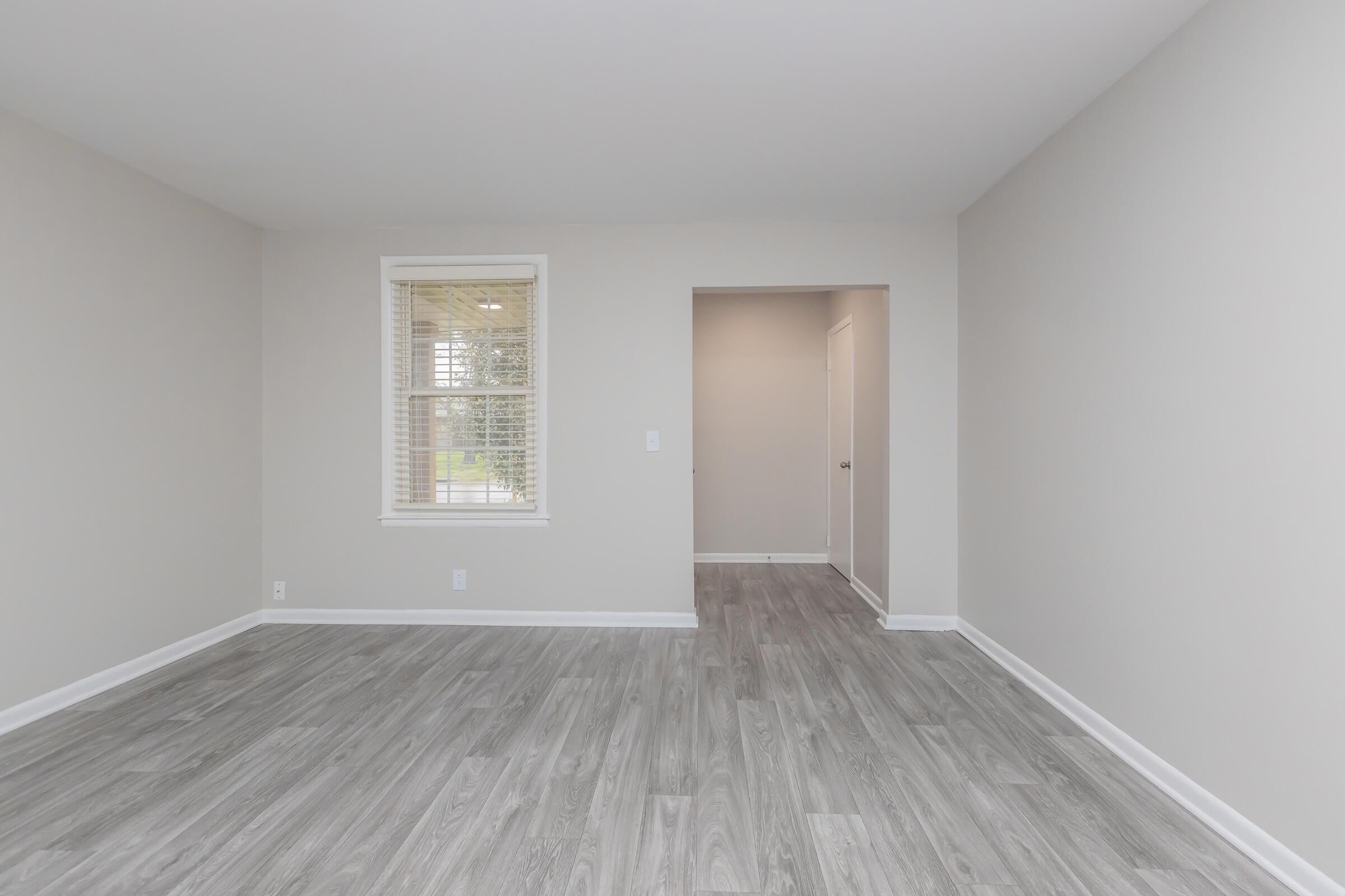 Living room with wood floors in The Nash apartment.