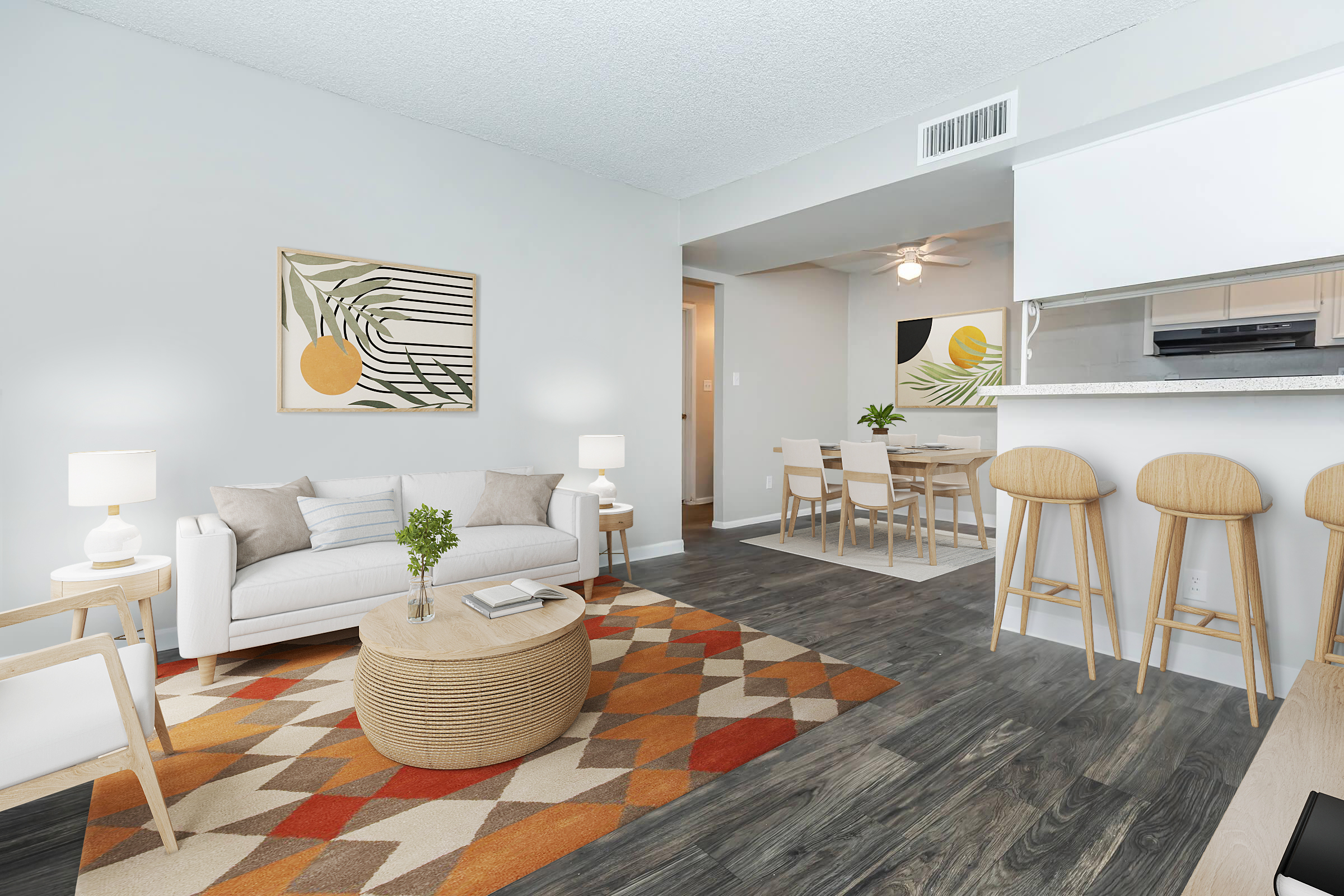 A modern, bright living space featuring a white sofa, a round wooden coffee table, and an orange and beige geometric area rug. Two stylish lamps flank the sofa, while a dining area with a wooden table and four chairs is visible in the background. Artwork with abstract designs adorns the walls, enhancing the contemporary feel.