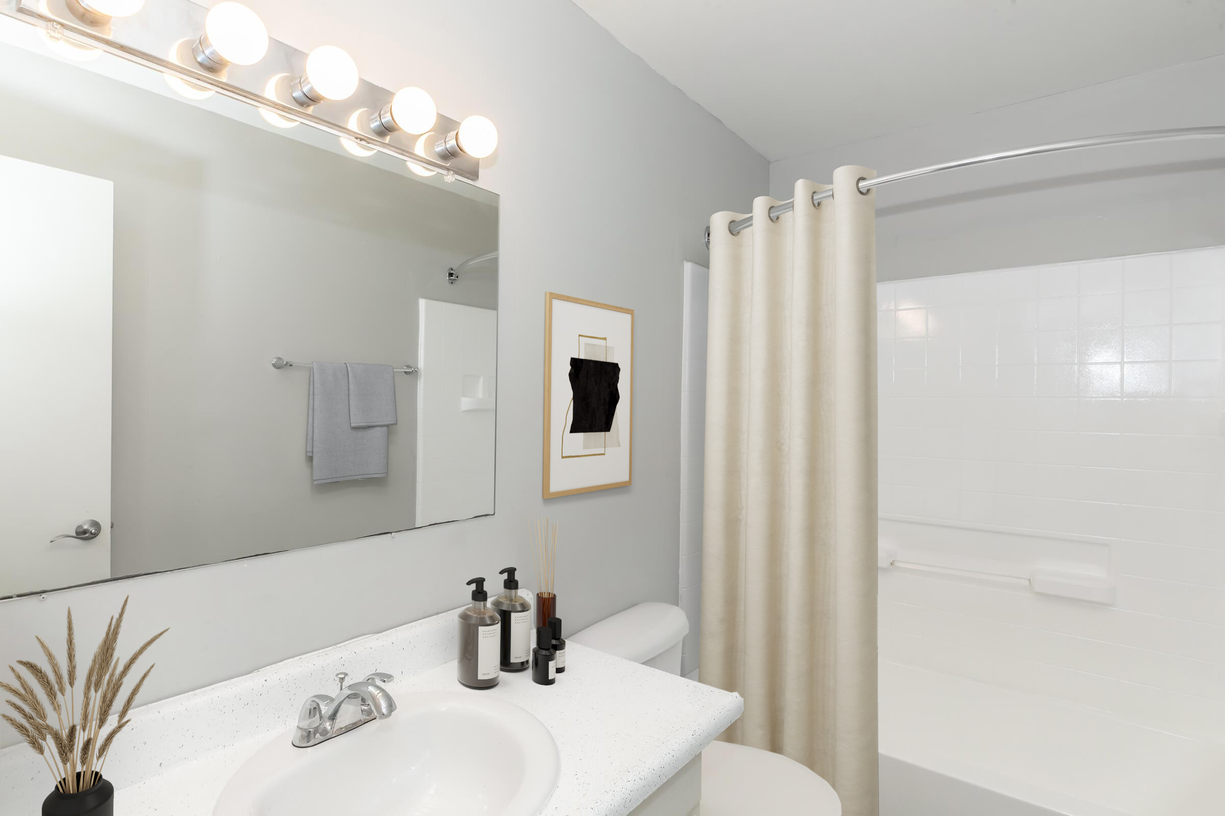 A modern bathroom featuring a white bathtub with a shower curtain, a large mirror with light fixtures above, a sink with stylish soap dispensers, and decorative items including a plant in a vase. A light gray wall complements the clean, minimalistic design.