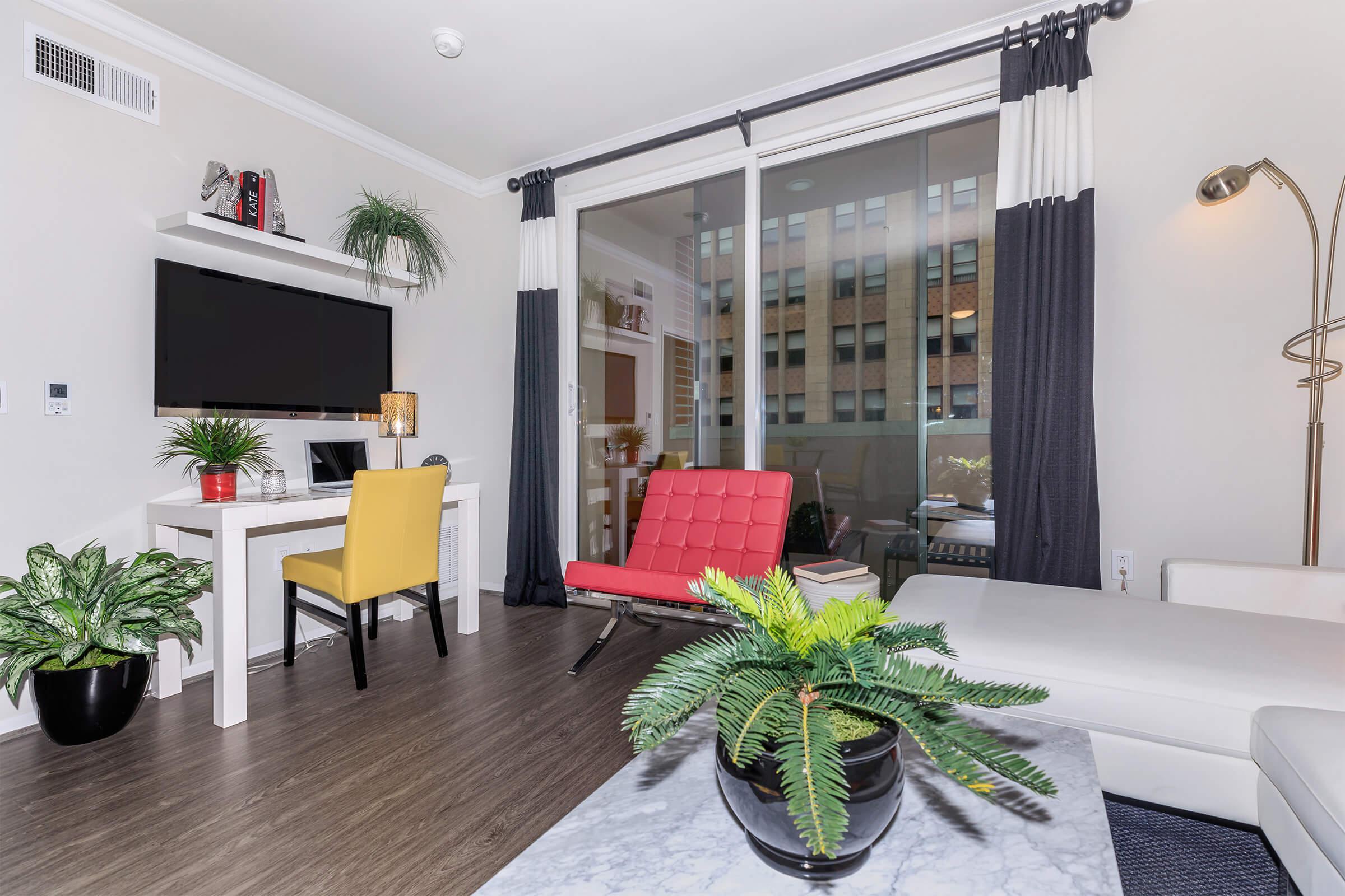 a living room filled with furniture and vase of flowers on a table