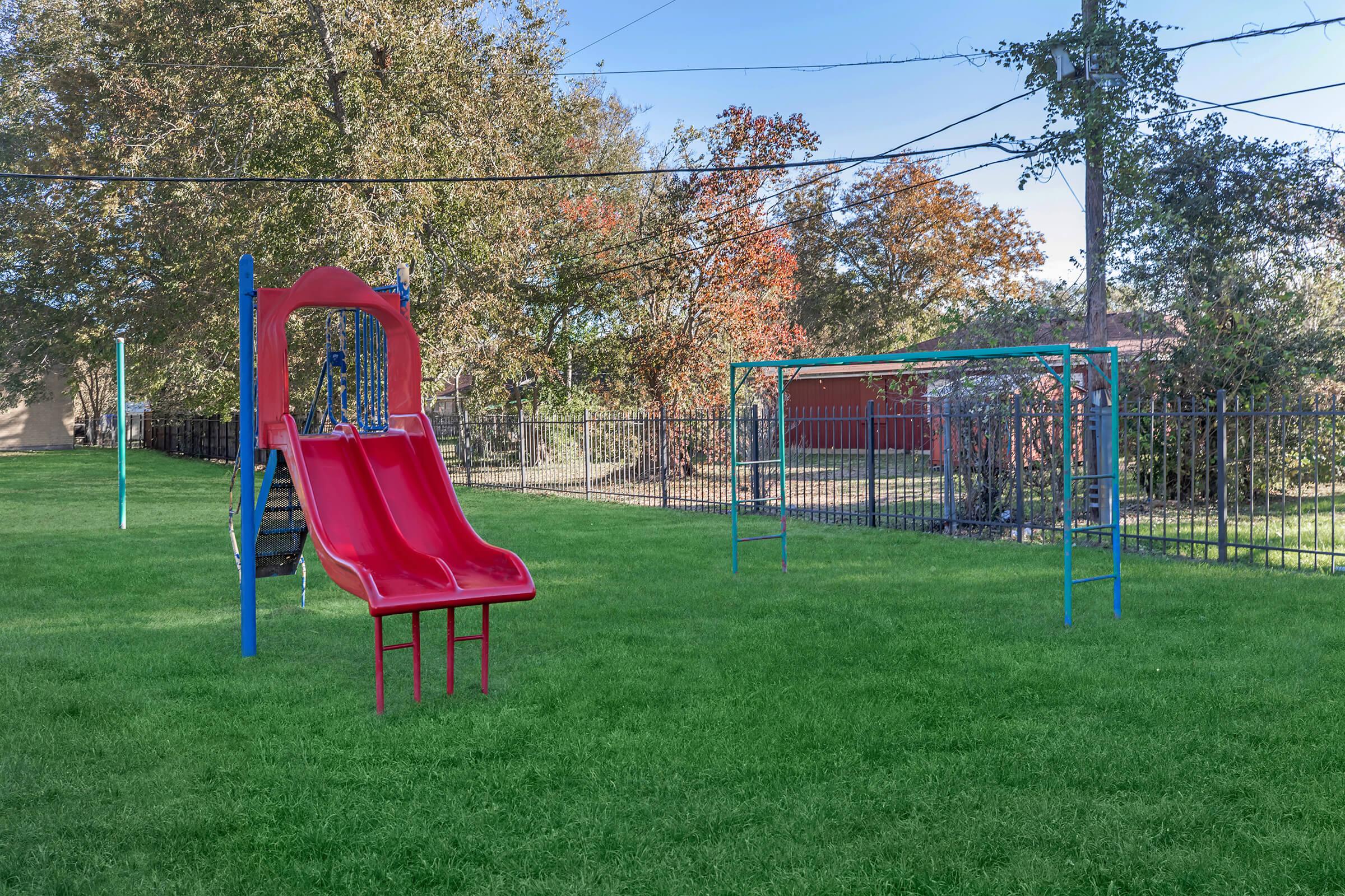 a playground with a blue seat on a slide