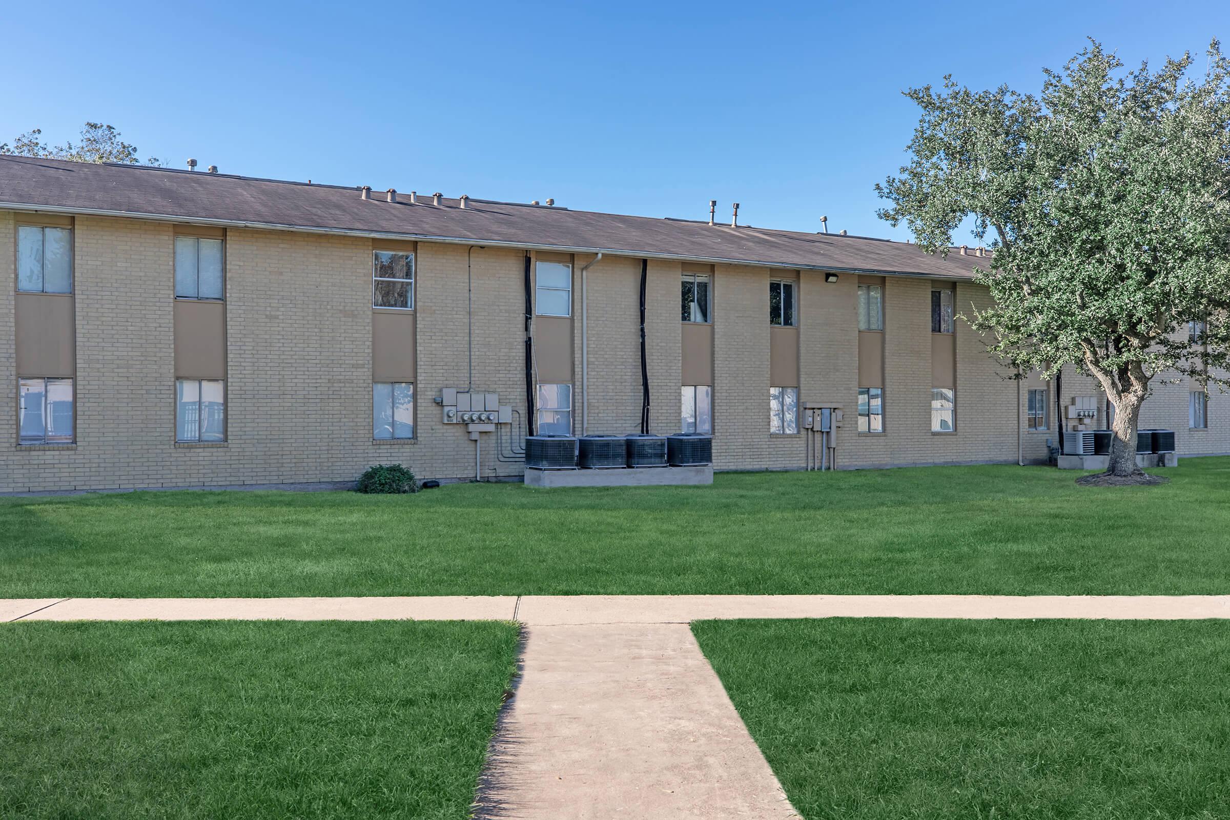 a large lawn in front of a brick building