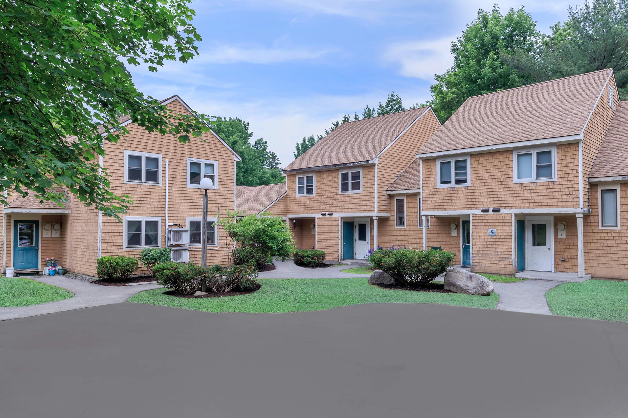 a large brick building with grass in front of a house