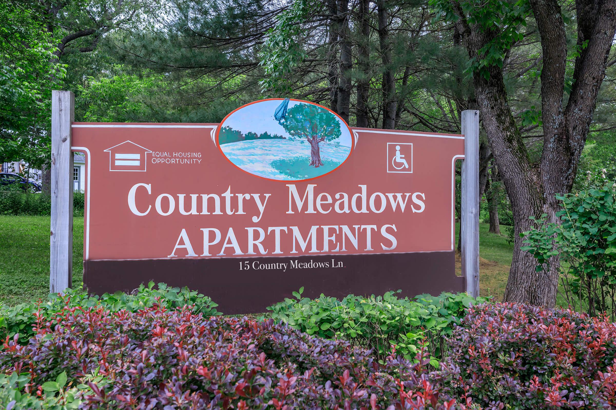 a sign in front of a flower garden