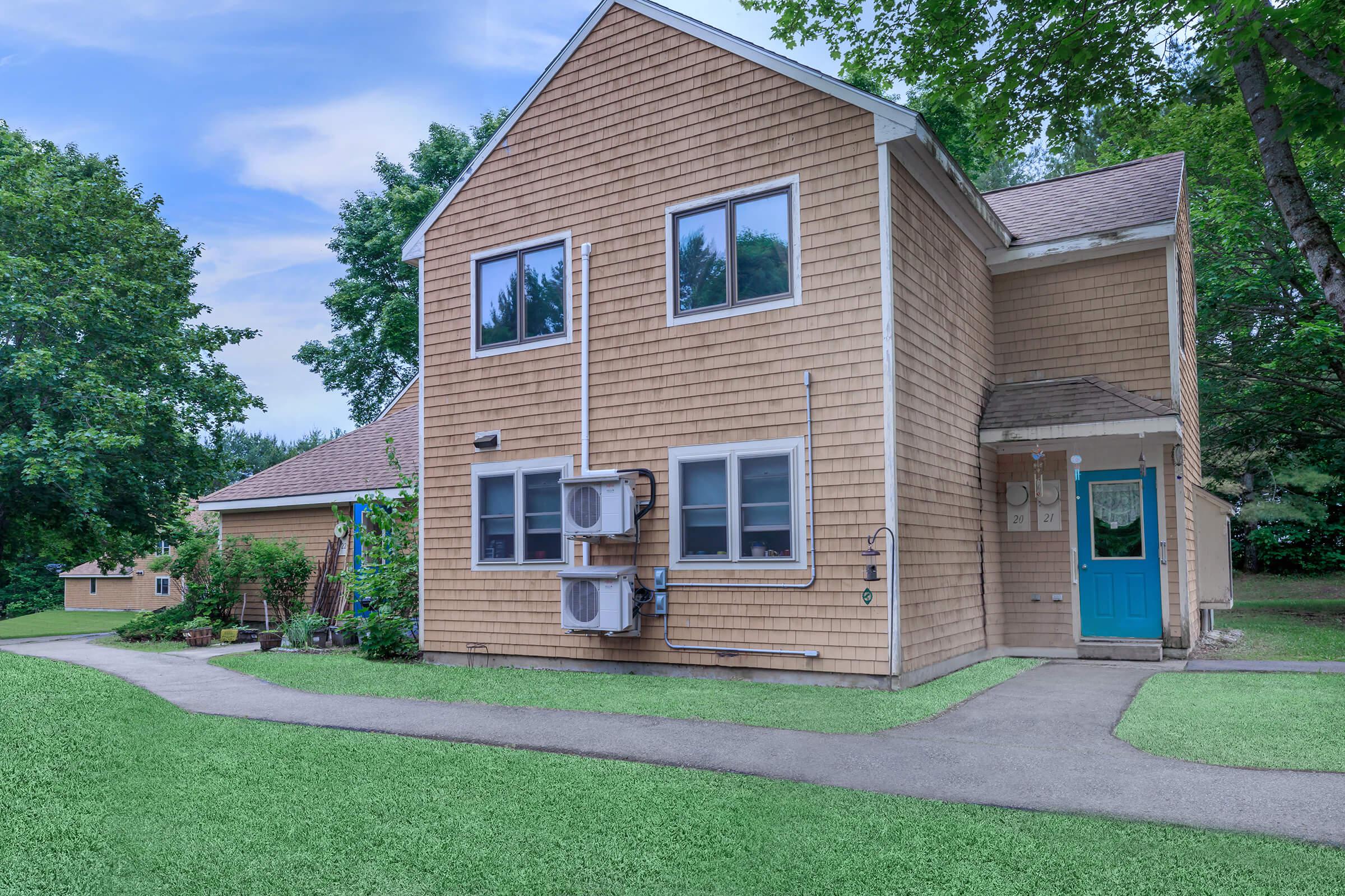 a house with a lawn in front of a brick building