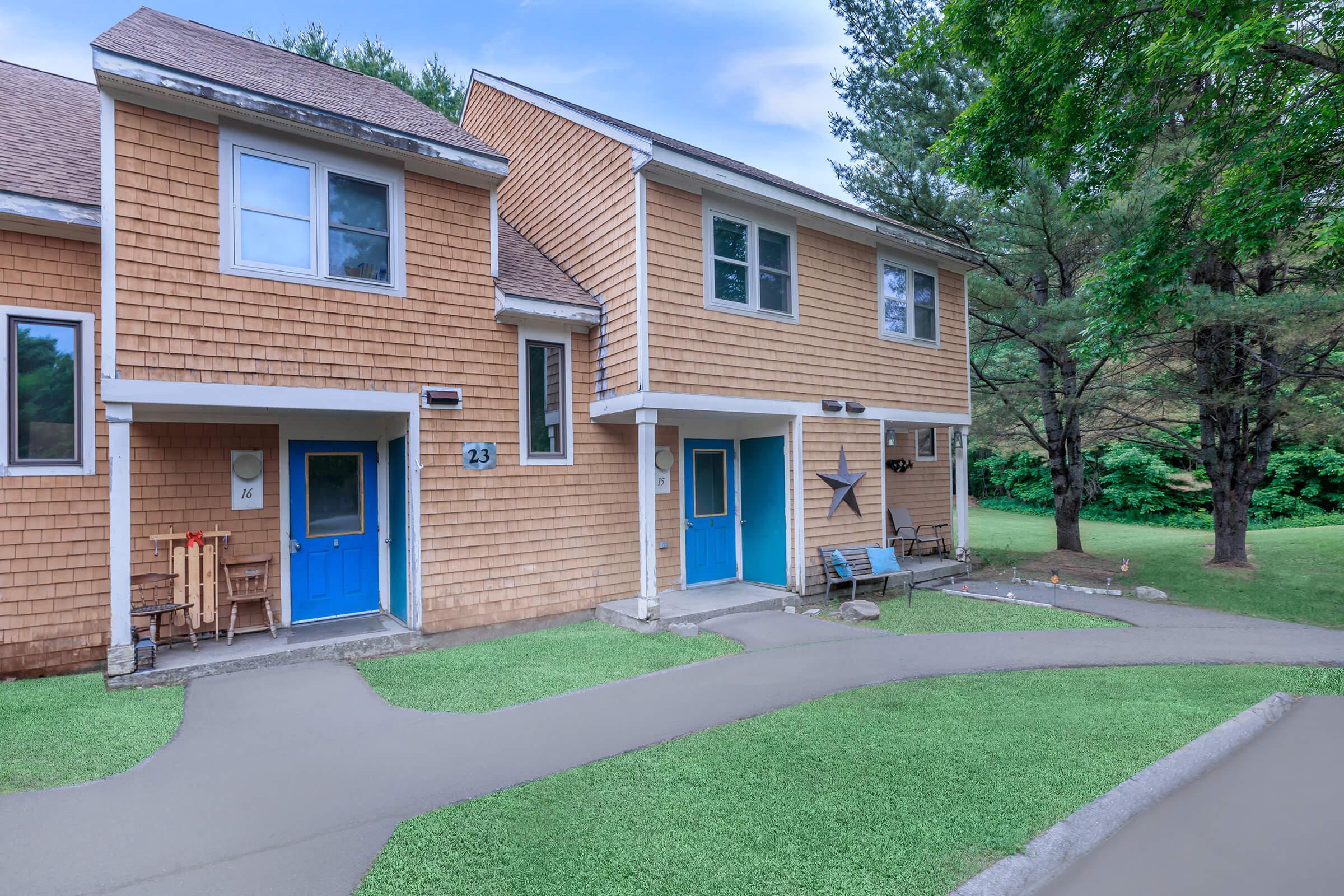 a house with a lawn in front of a brick building