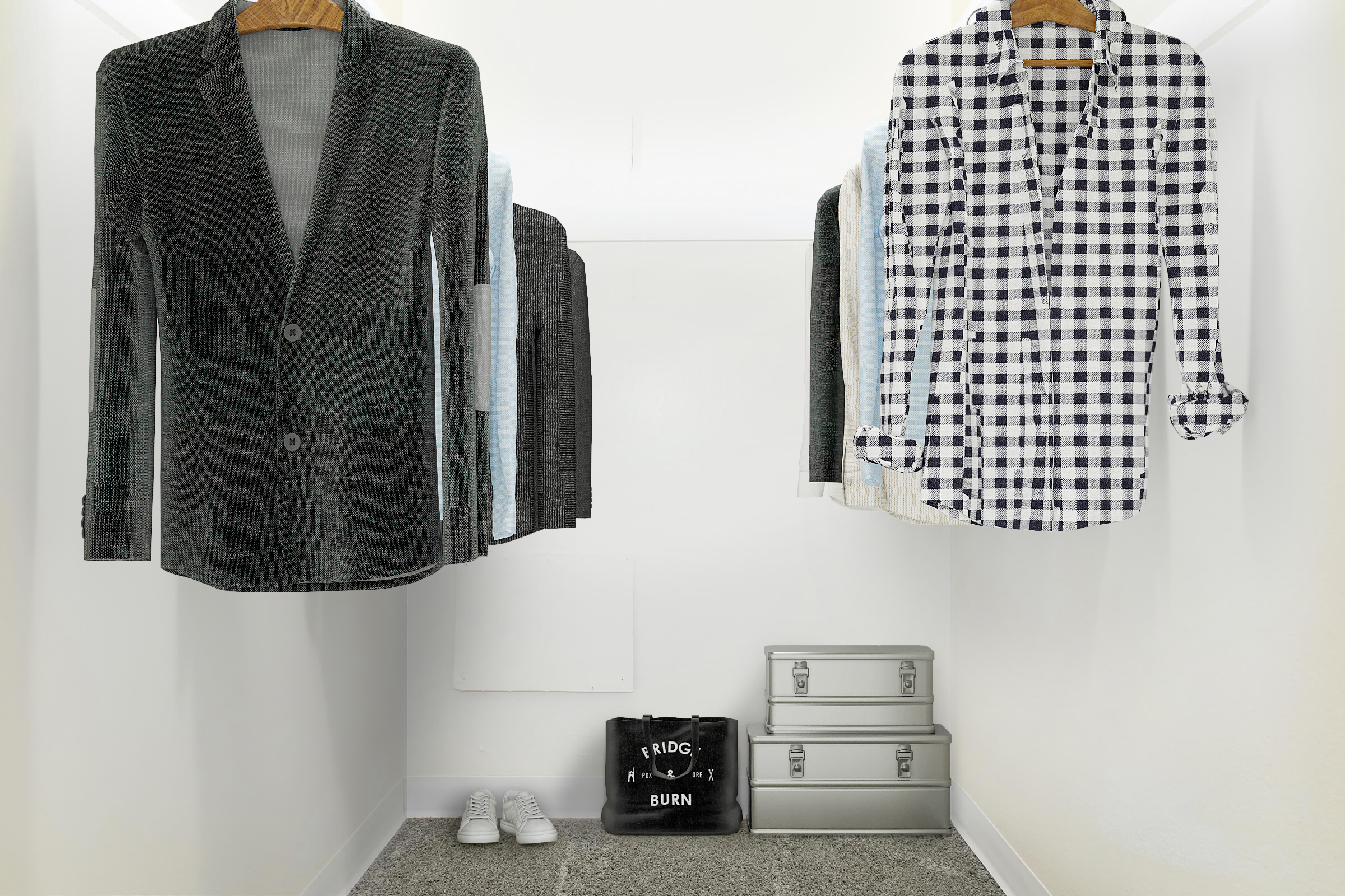 A minimalist closet with a gray blazer and a black-and-white checked shirt hanging on hangers. Below, there are two silver storage boxes and a pair of white sneakers on the floor. A stylish black tote bag with a graphic design is also present, adding a touch of personal style to the space.