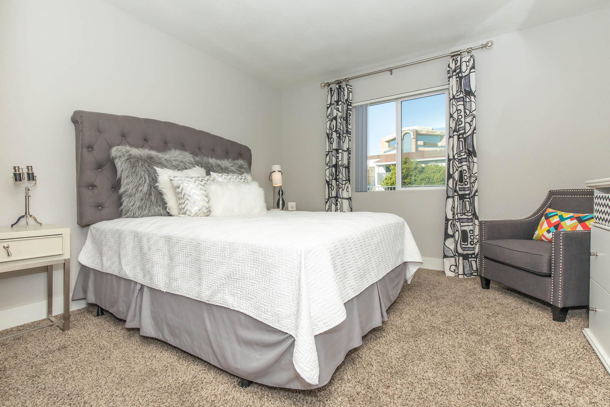 a bedroom with a bed and desk in a room